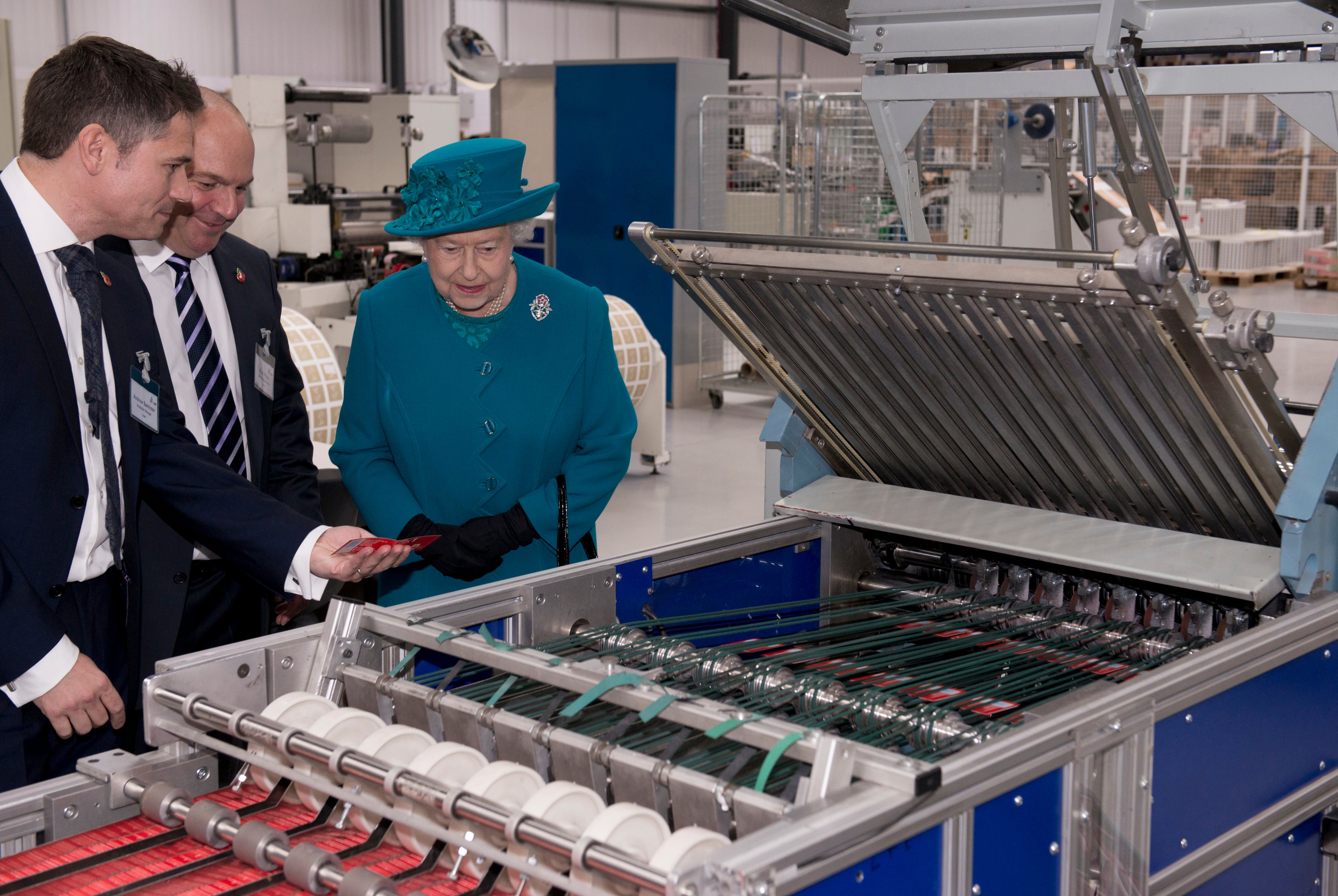 The Queen being shown stamp cutting and finishing machines during a visit to International Security Printers to view their work on specialist postage stamps