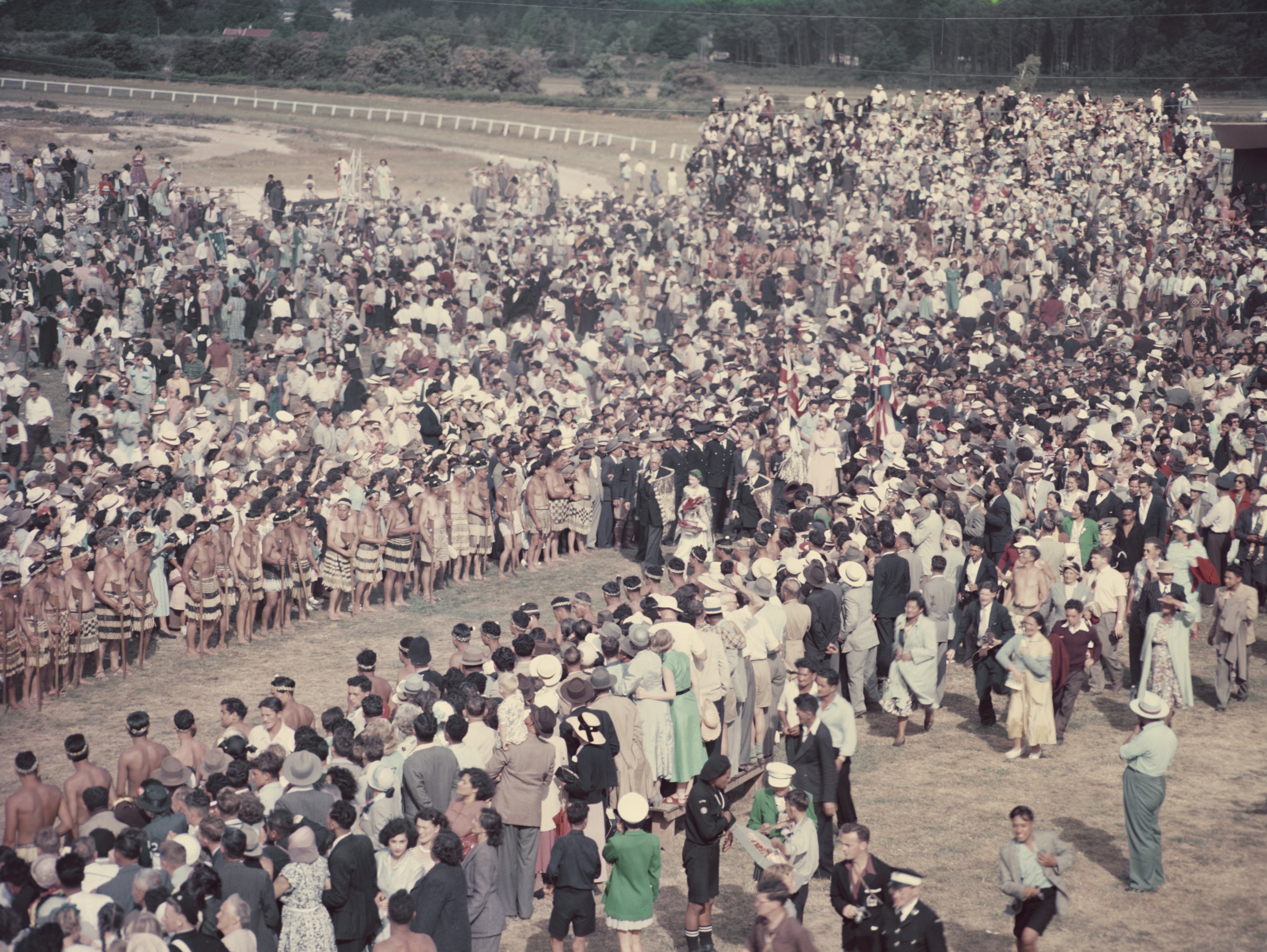 Queen Elizabeth II and Prince Philip walk through the crowd during her visit to New Zealand in January 1954. She was met by around 20,000 Maoris