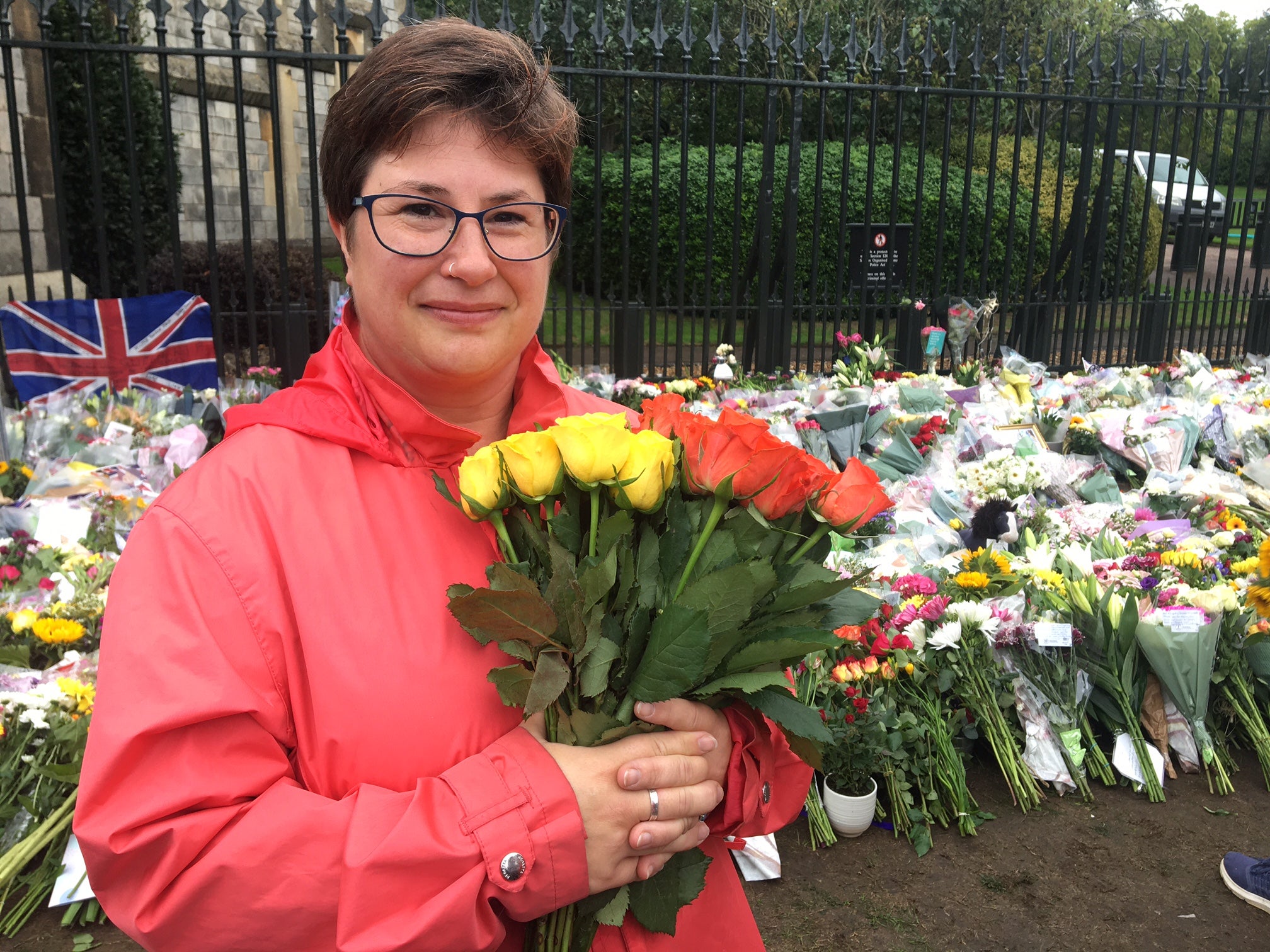 Chrissi Frewer cluches a bouquet of flowers outside Windsor Castle