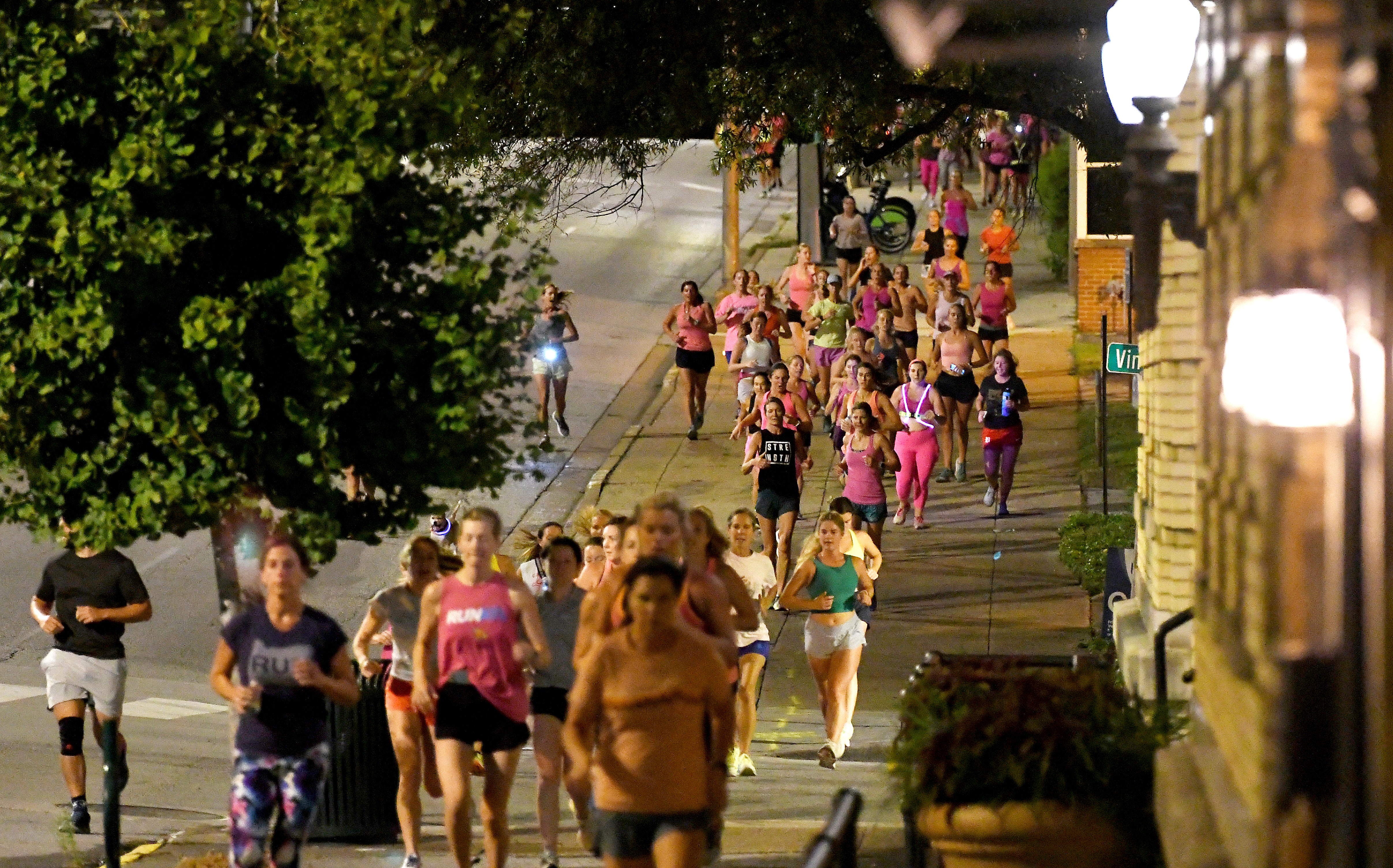 Runners head down the sidewalk past Fountain Square during ‘Finish Eliza’s Run’ on Friday morning in Chattanooga, Tennessee