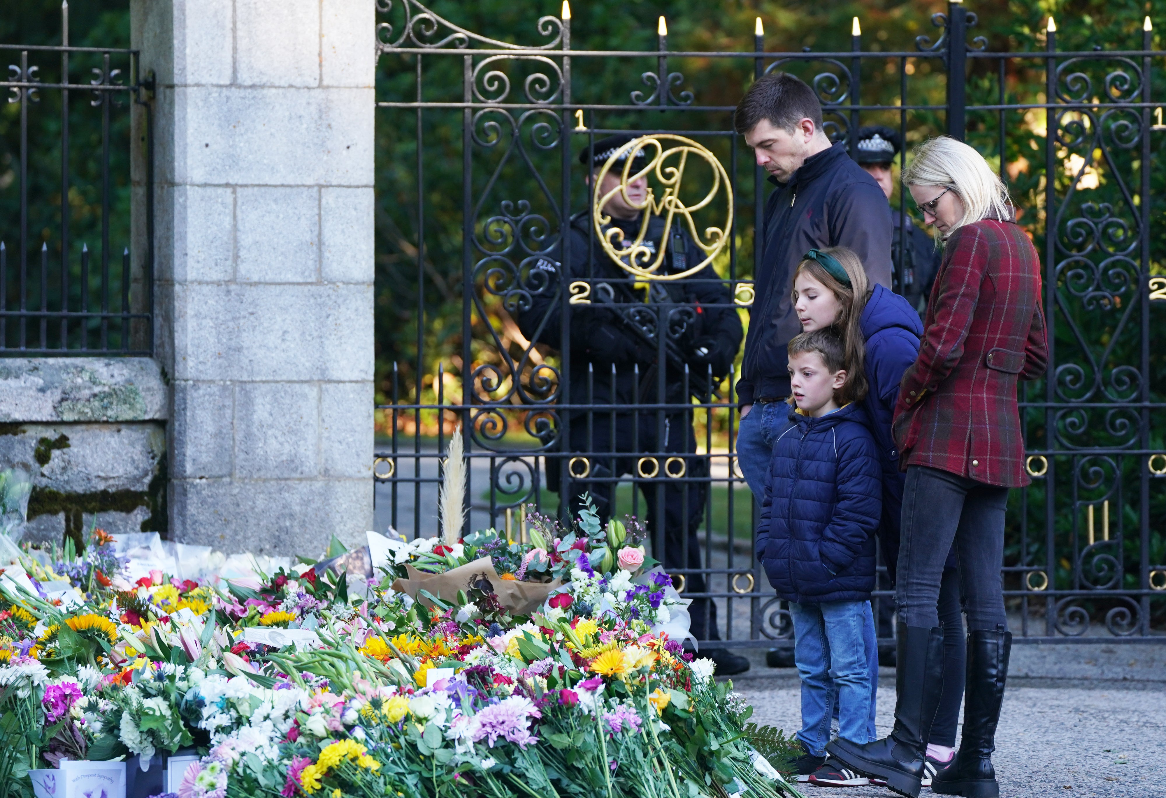 Members of the public look at floral tributes at Balmoral in Scotland following the death of the Queen on Thursday (Andrew Milligan/PA)