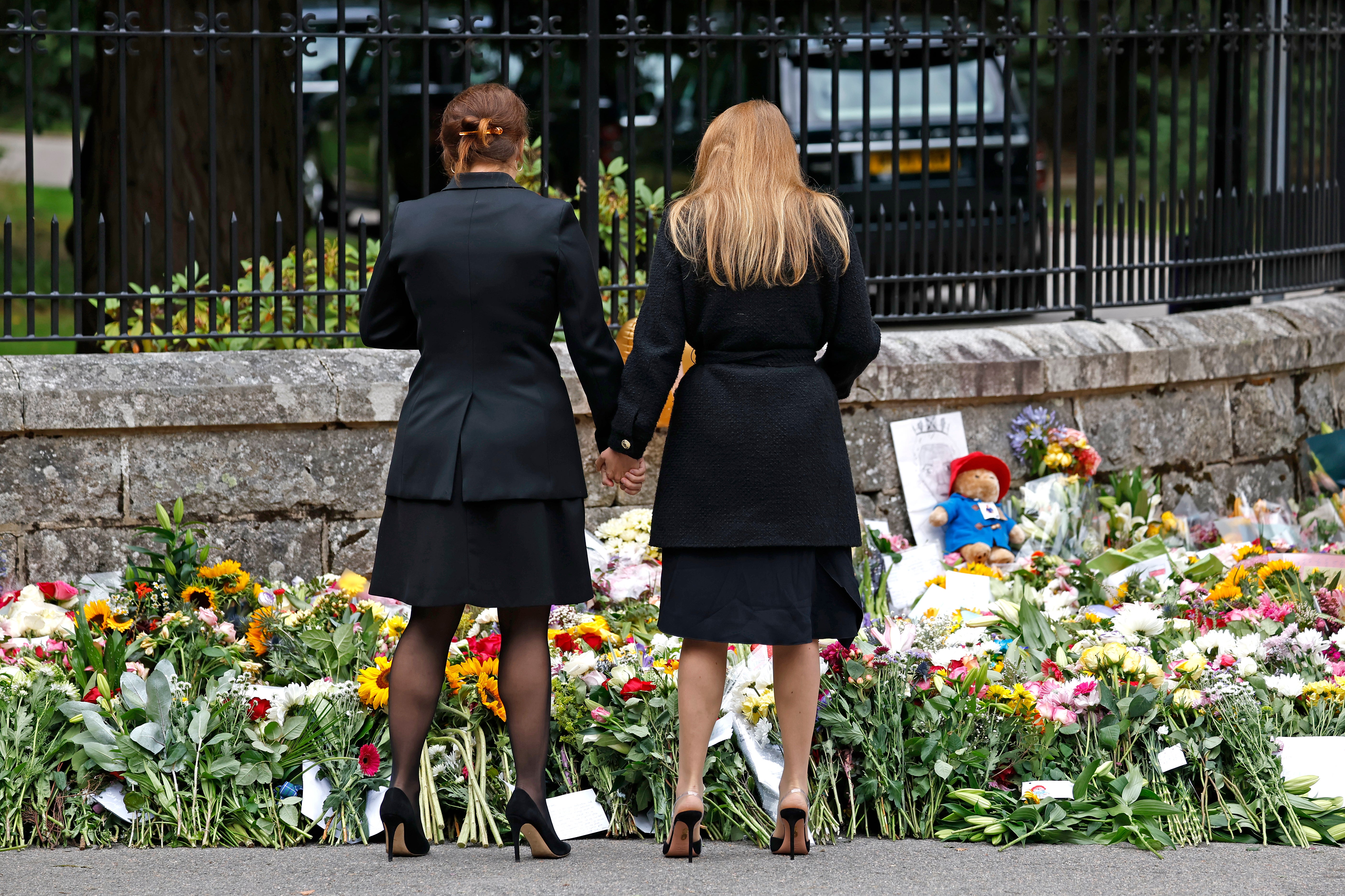 Princess Beatrice (r) and Princess Eugenie (l) admiring the floral tributes outside Balmoral