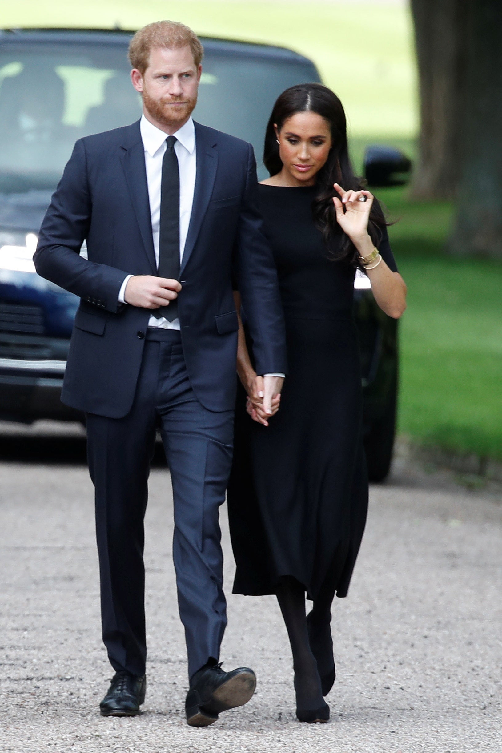 The Duke and Duchess of Sussex walking outside Windsor Castle to view floral tributes to the Queen