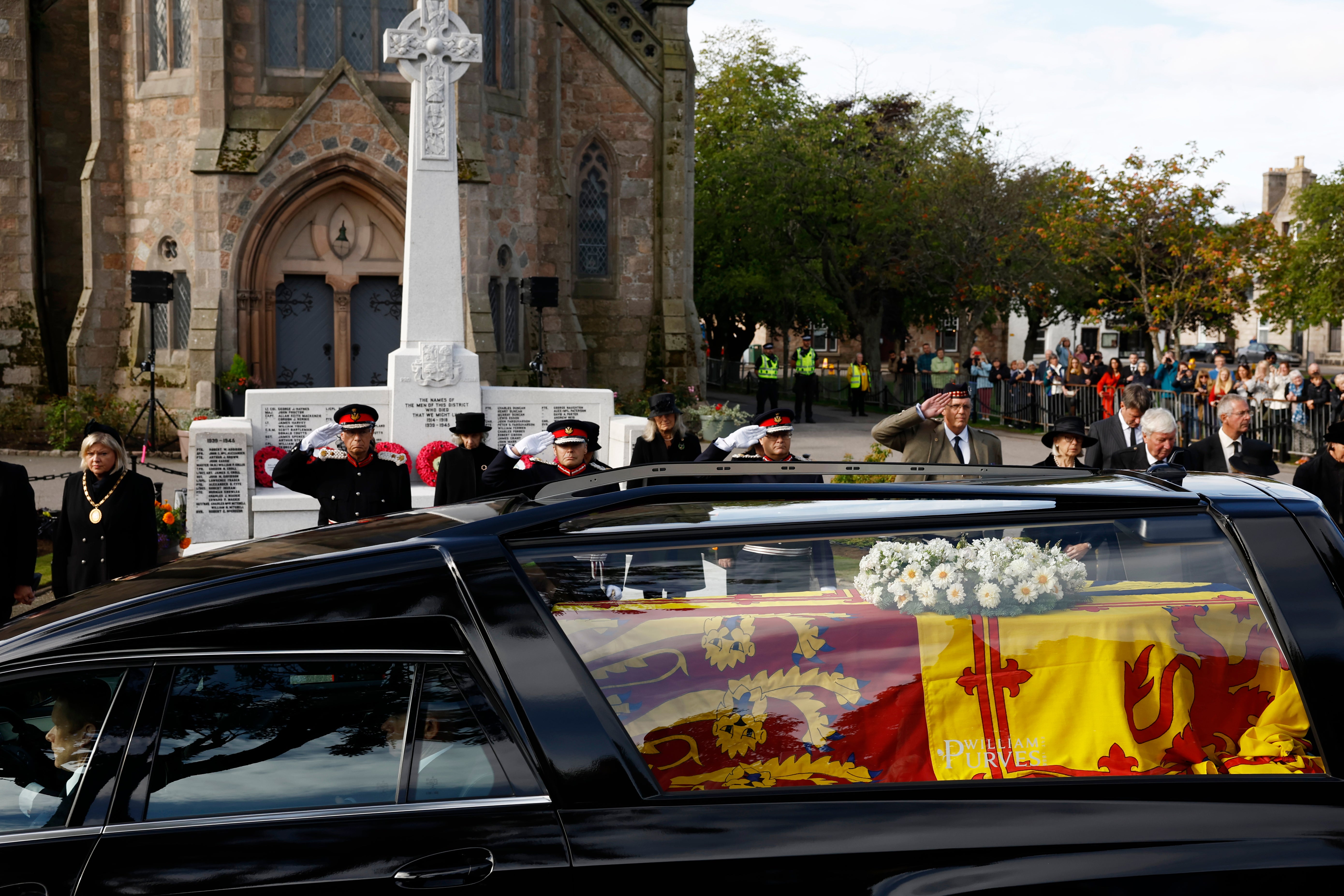 Well wishers pay their respects as the coffin passes along the route