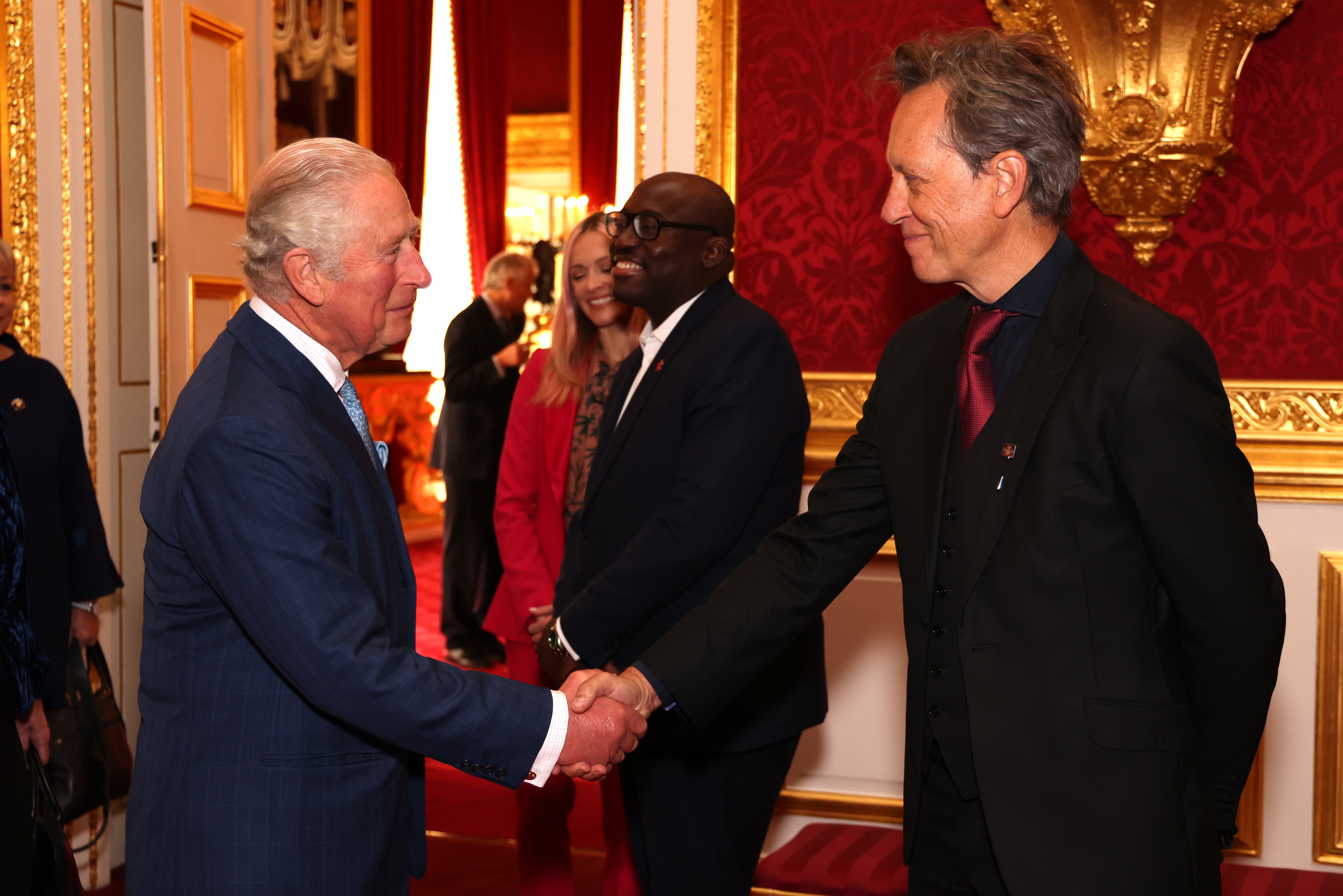 The Prince of Wales, now King Charles III, shakes hands with Richard E Grant