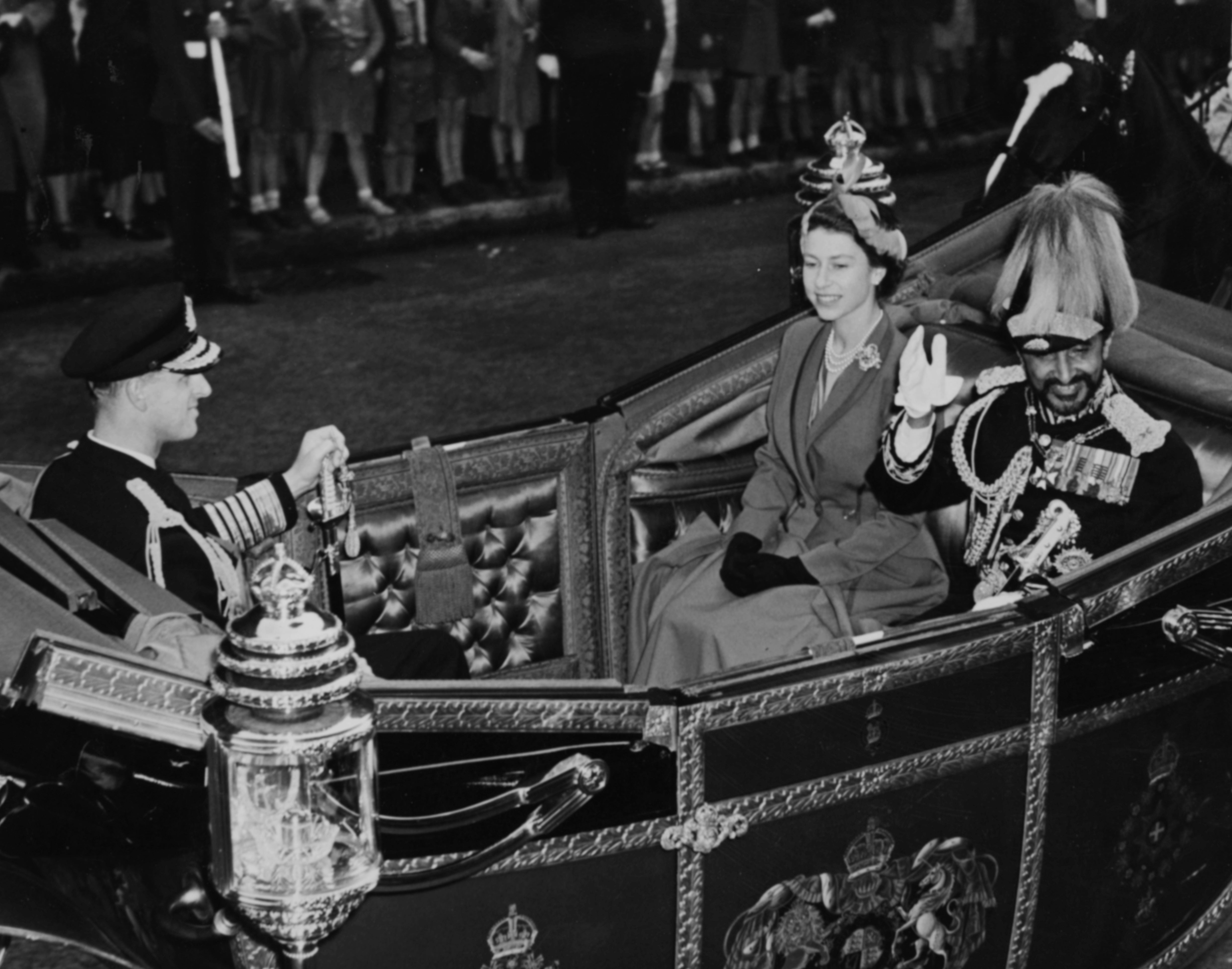 The Queen and Prince Philip ride in an open Landau carriage in London with Emperor Haile Selassie of Ethiopia during his state visit on 14 October 1954