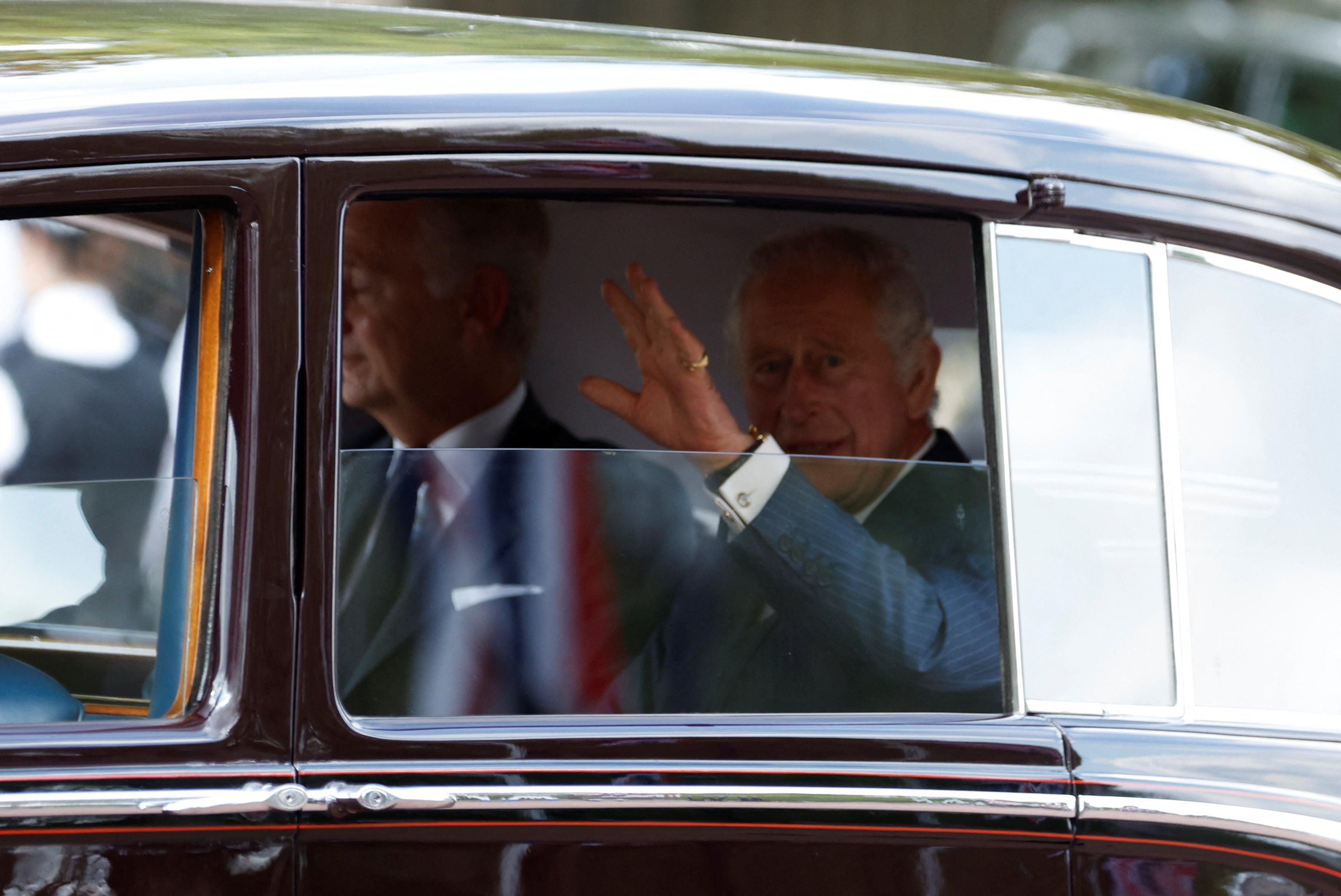 King Charles III waved to the crowd as he arrived at Buckingham Palace