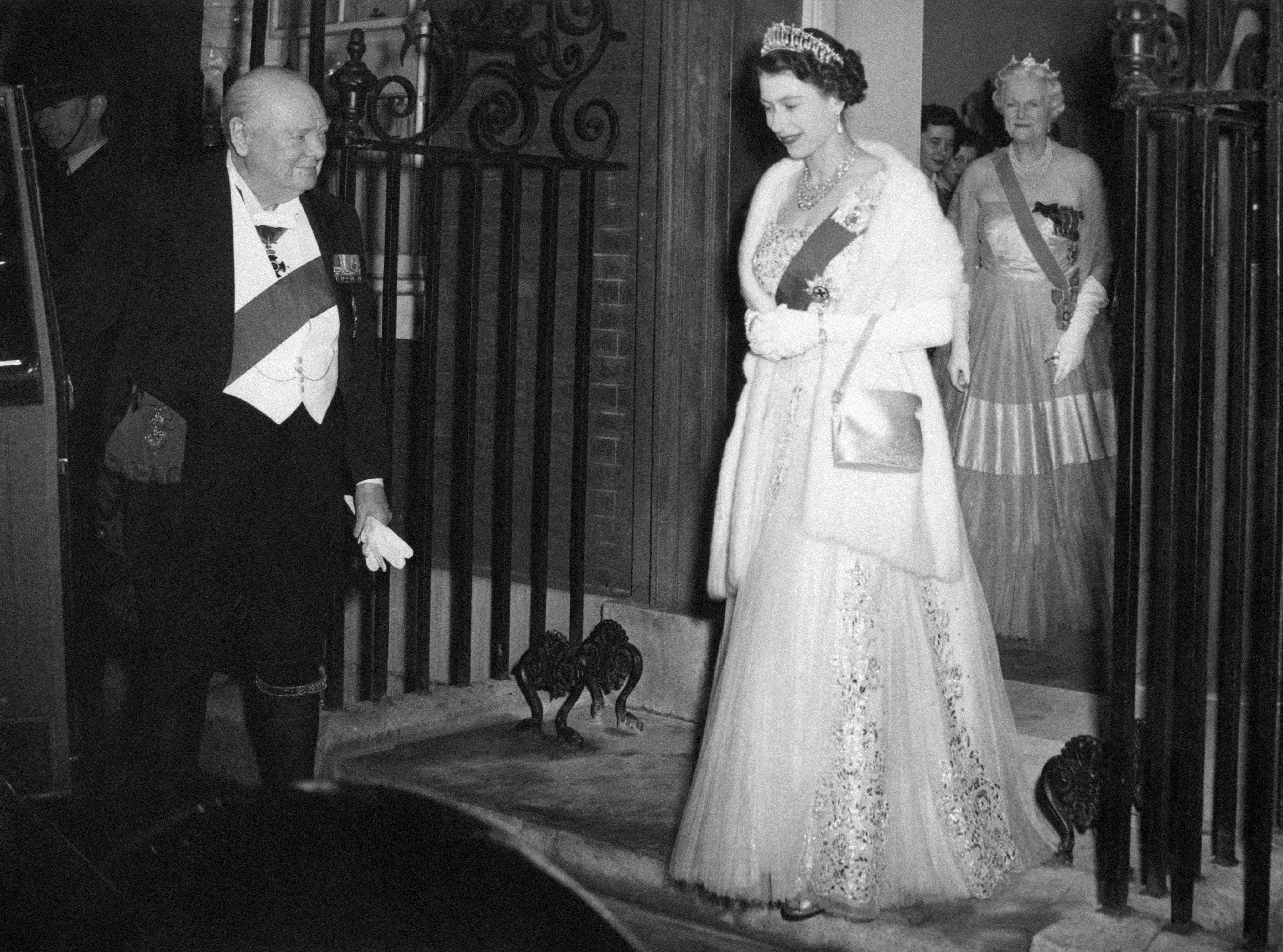 Sir Winston Churchill opening the door of Queen Elizabeth’s car, as she and the Duke of Edinburgh leave after dining with him and other guests in 1955