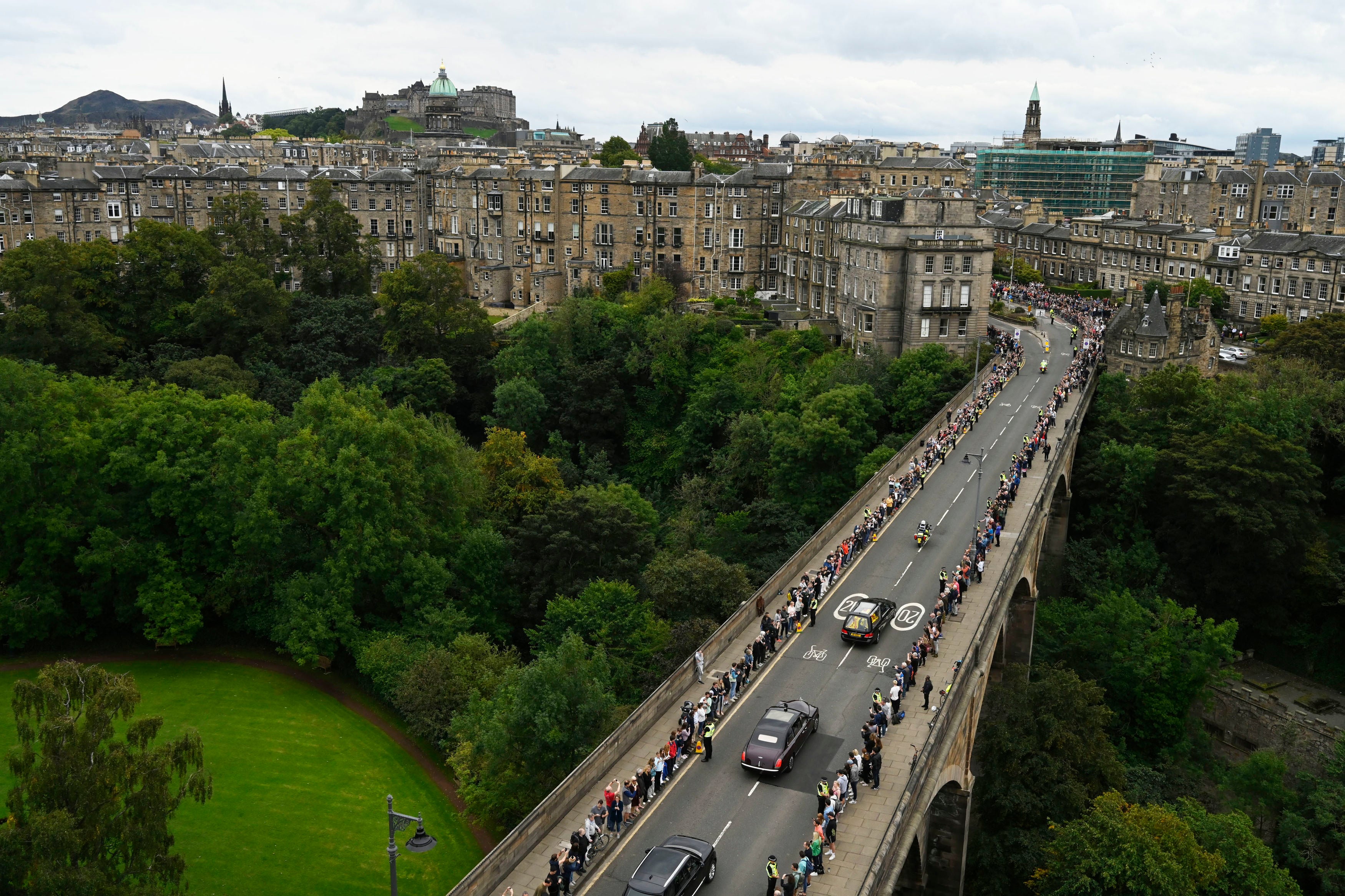 The hearse carrying the coffin, draped with the Royal Standard of Scotland, passing through the outskirts of Edinburgh