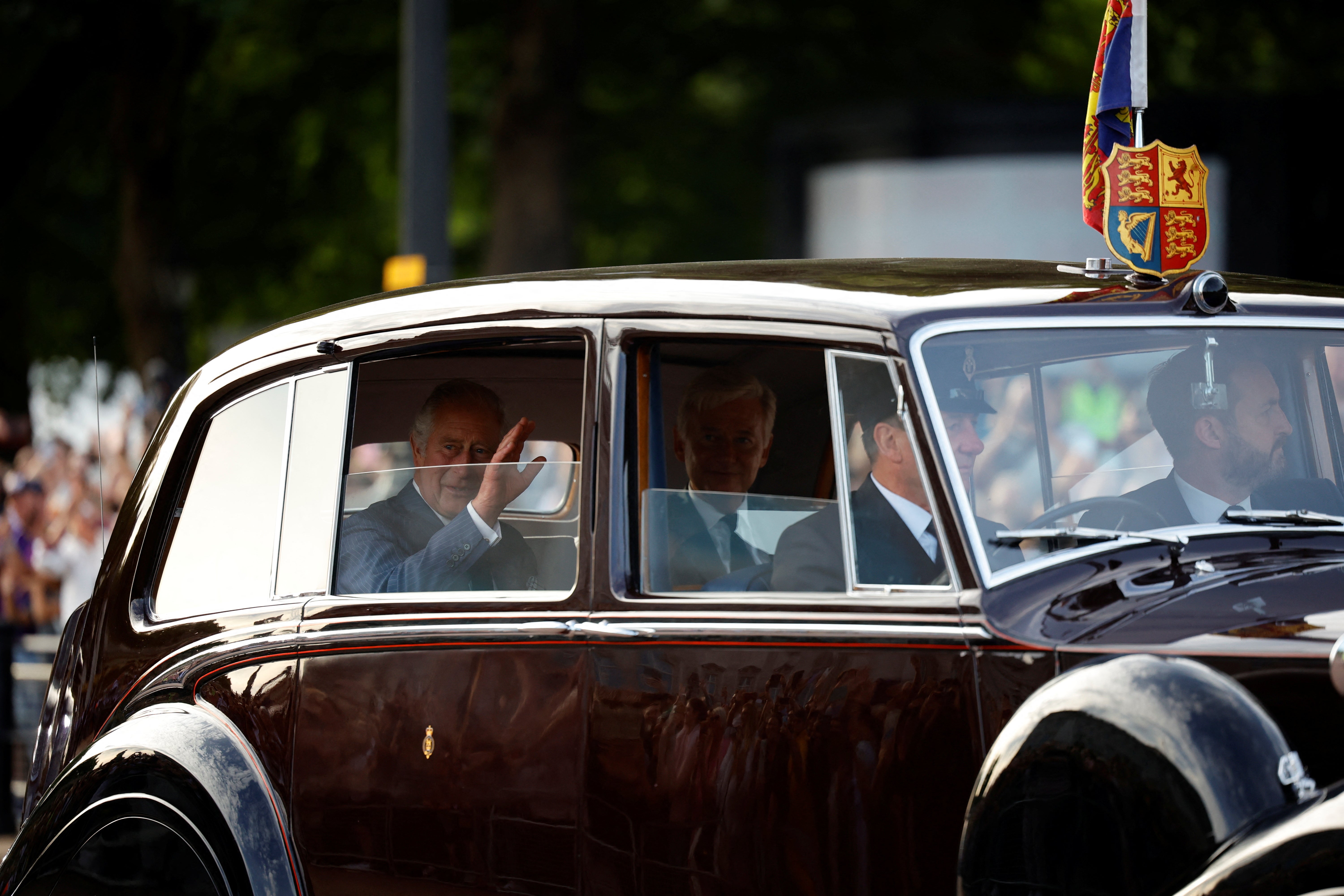 King Charles acknowledges the cheers along The Mall