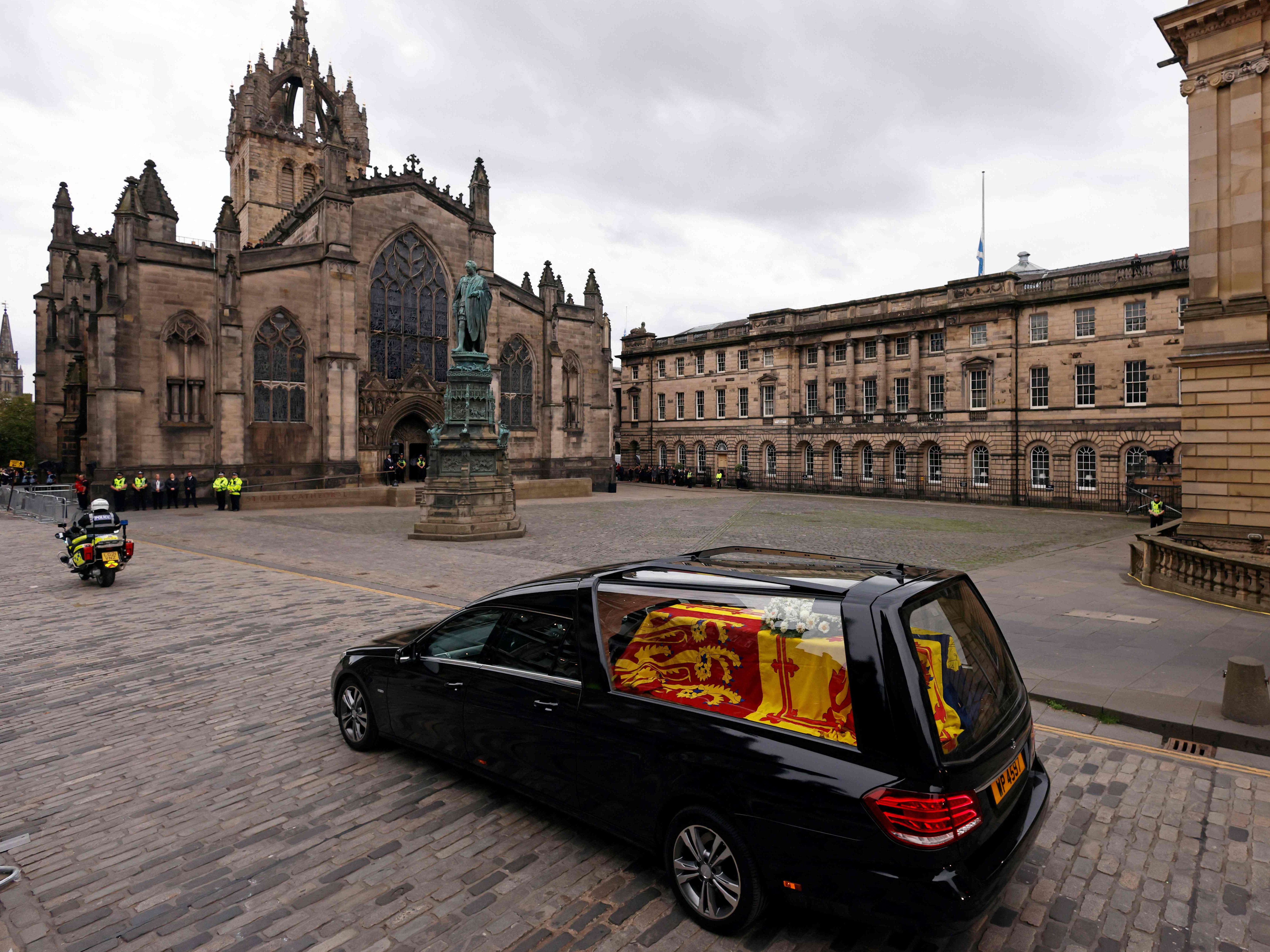 The hearse, draped in the Royal Standard of Scotland, is driven through Edinburgh towards the Palace of Holyroodhouse