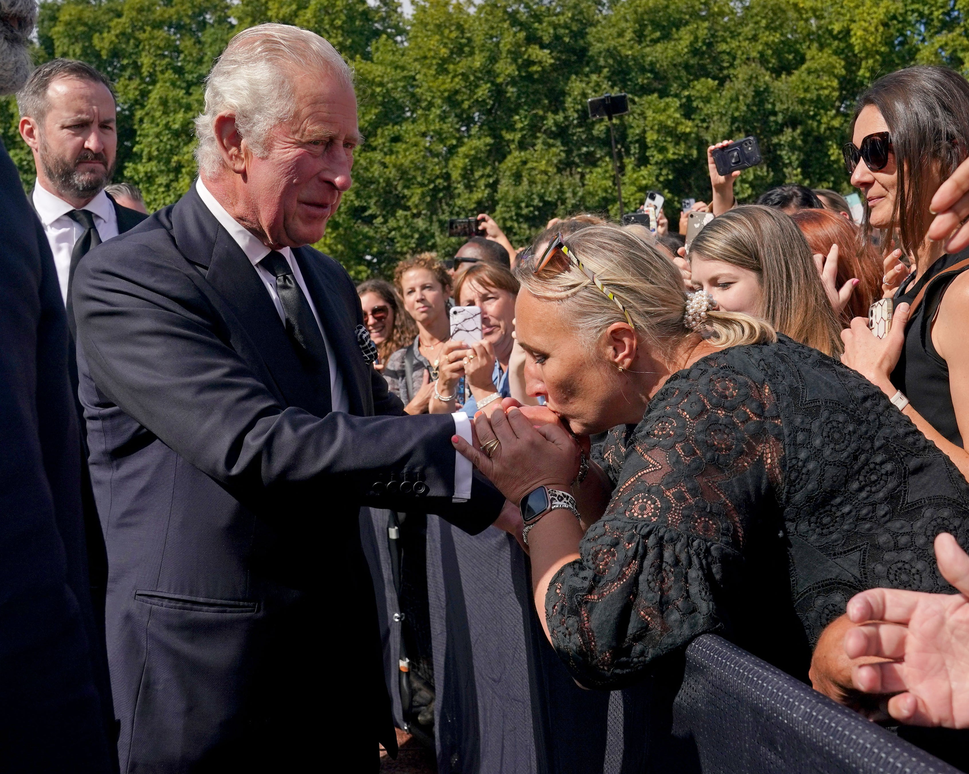 A well-wisher kisses the King’s hand during a walkabout outside Buckingham Palace on Thursday (Yui Mok/PA)