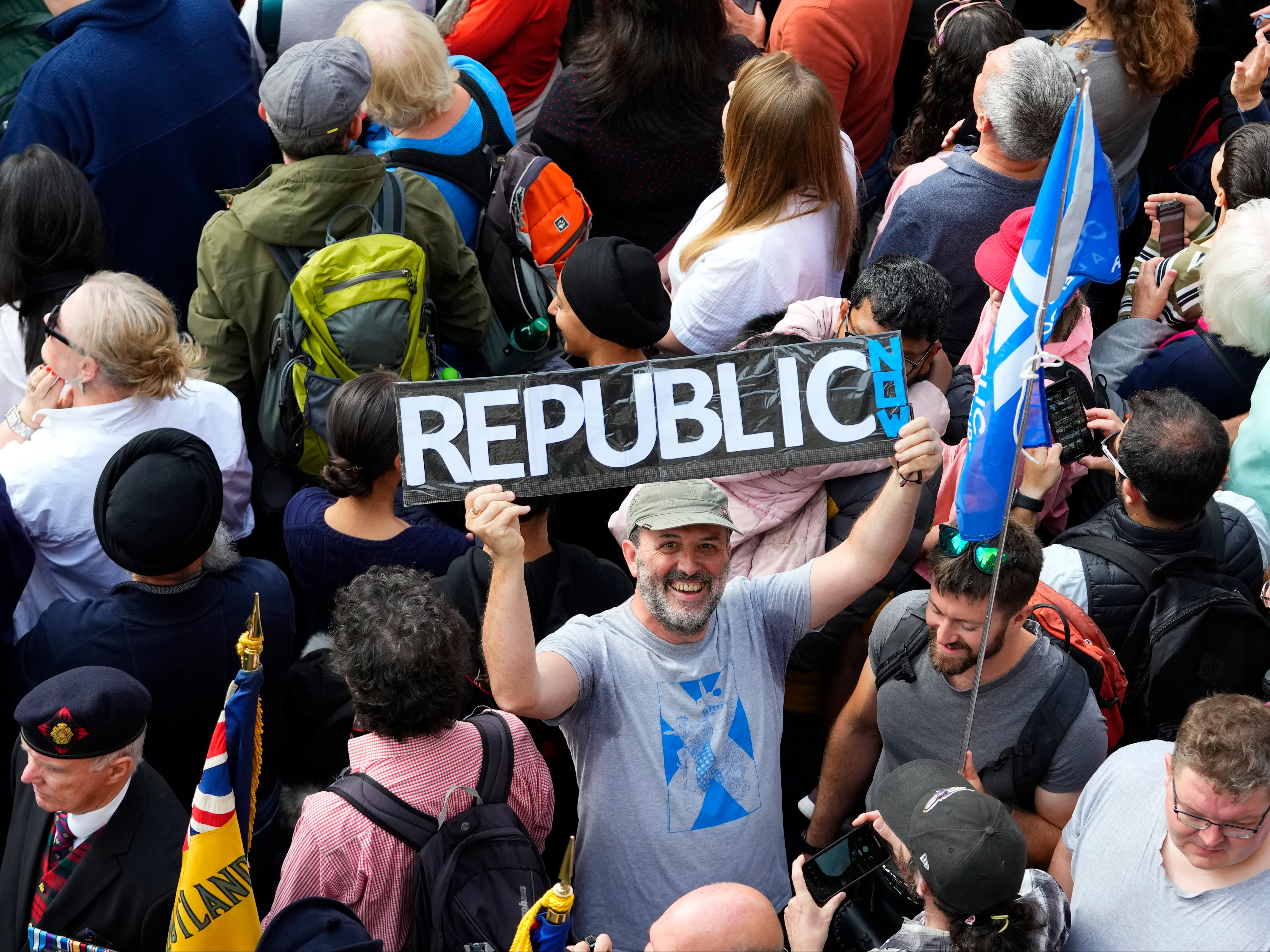 A man holds up a sign at a public proclamation to announce the accession of King Charles III, outside St Giles’ Cathedral in Edinburgh