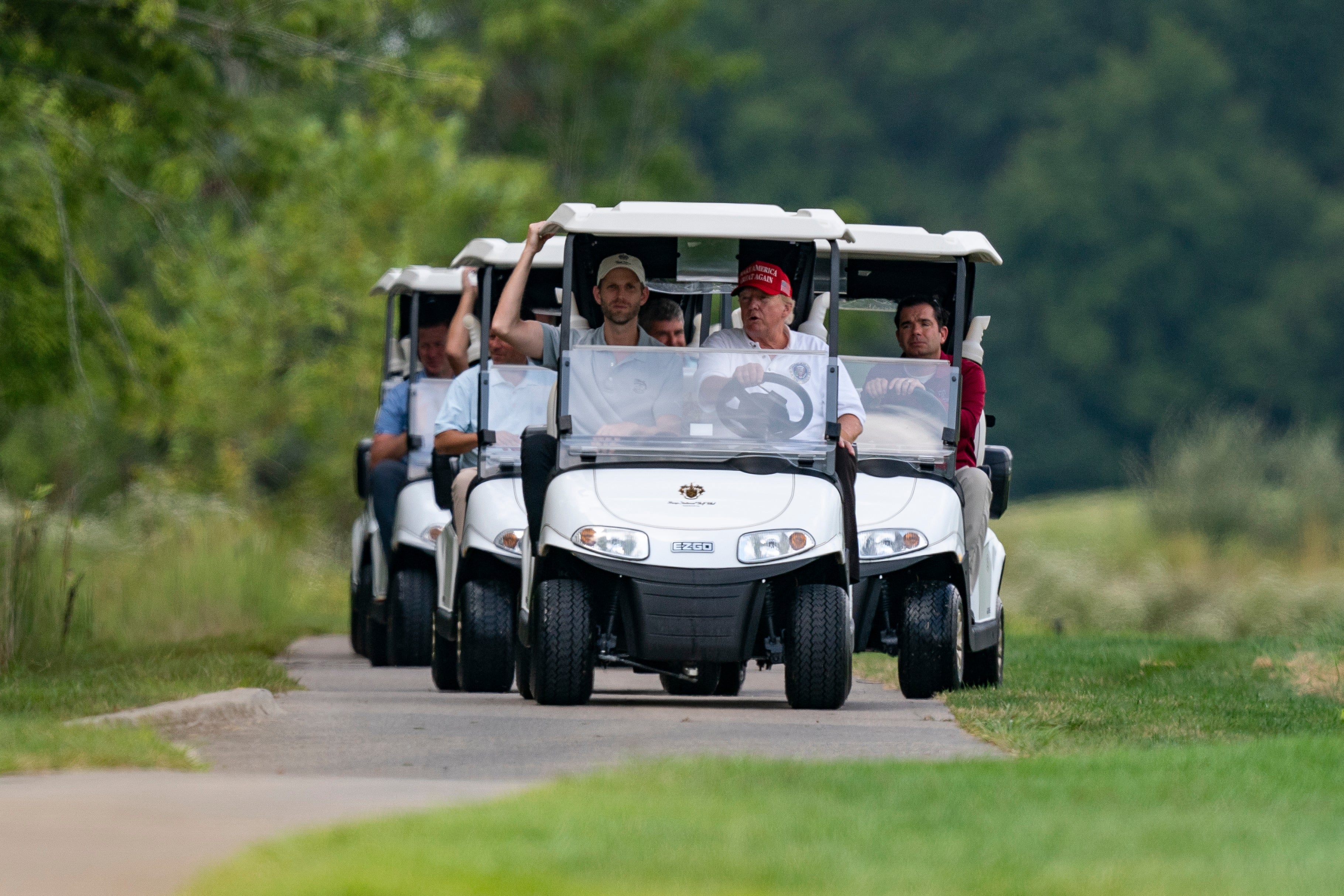 Trump and his son Eric seen leading a convoy of golf carts