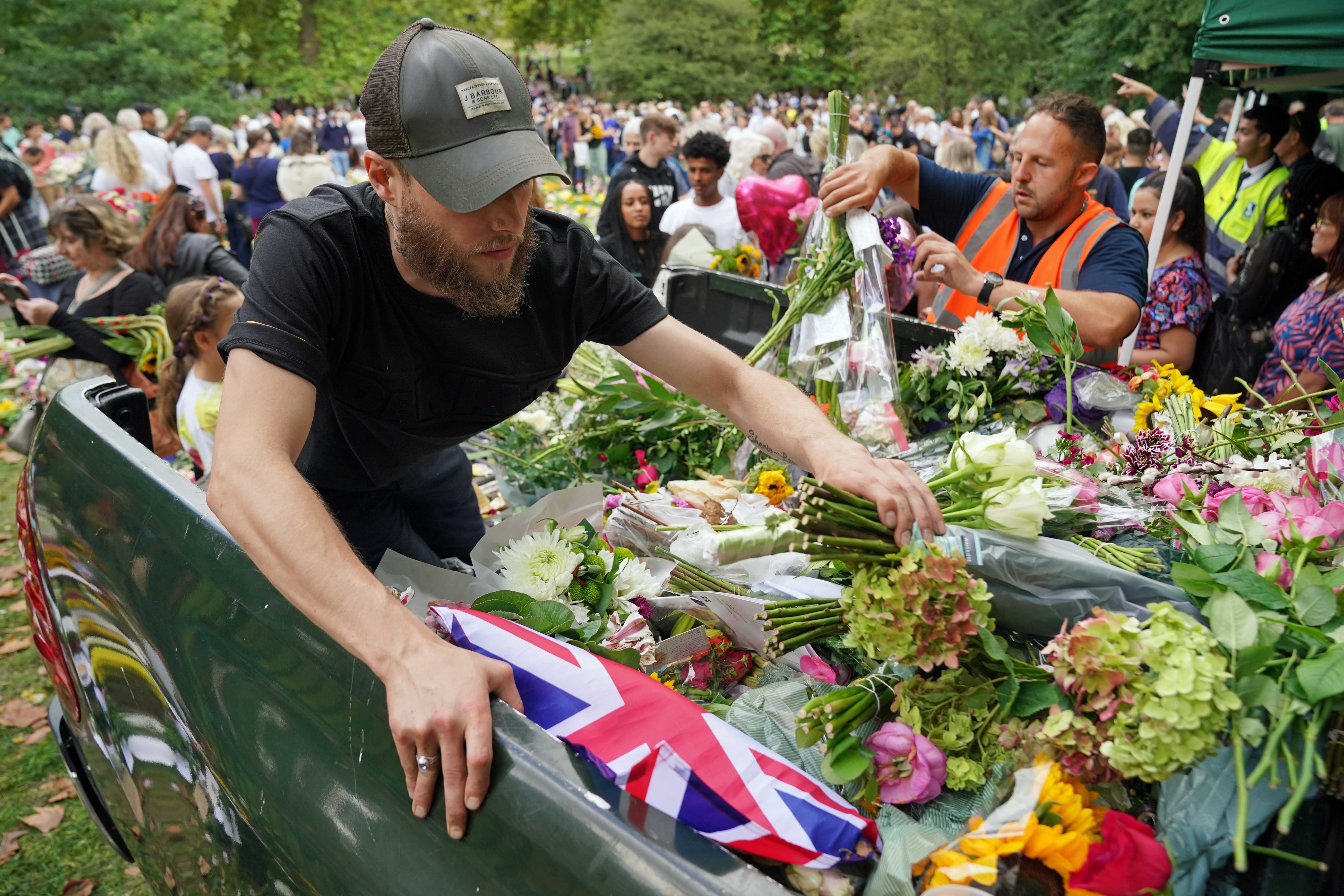 Staff from the Royal household distribute flowers to the public in Green Park, near Buckingham Palace, London.