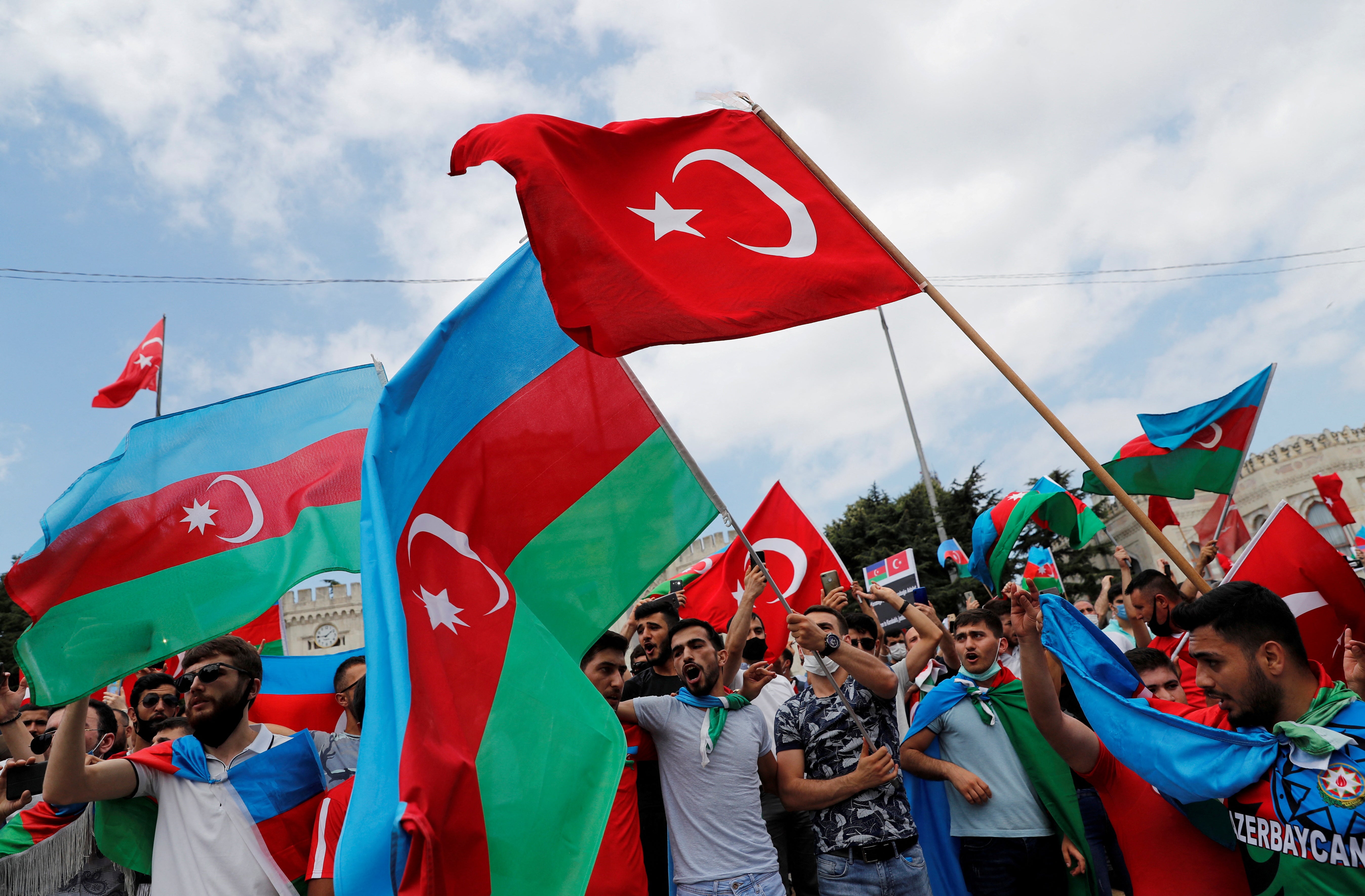 Azerbaijani men wave the flags of Turkey and Azerbaijan in Istanbul on 19 July, 2020.