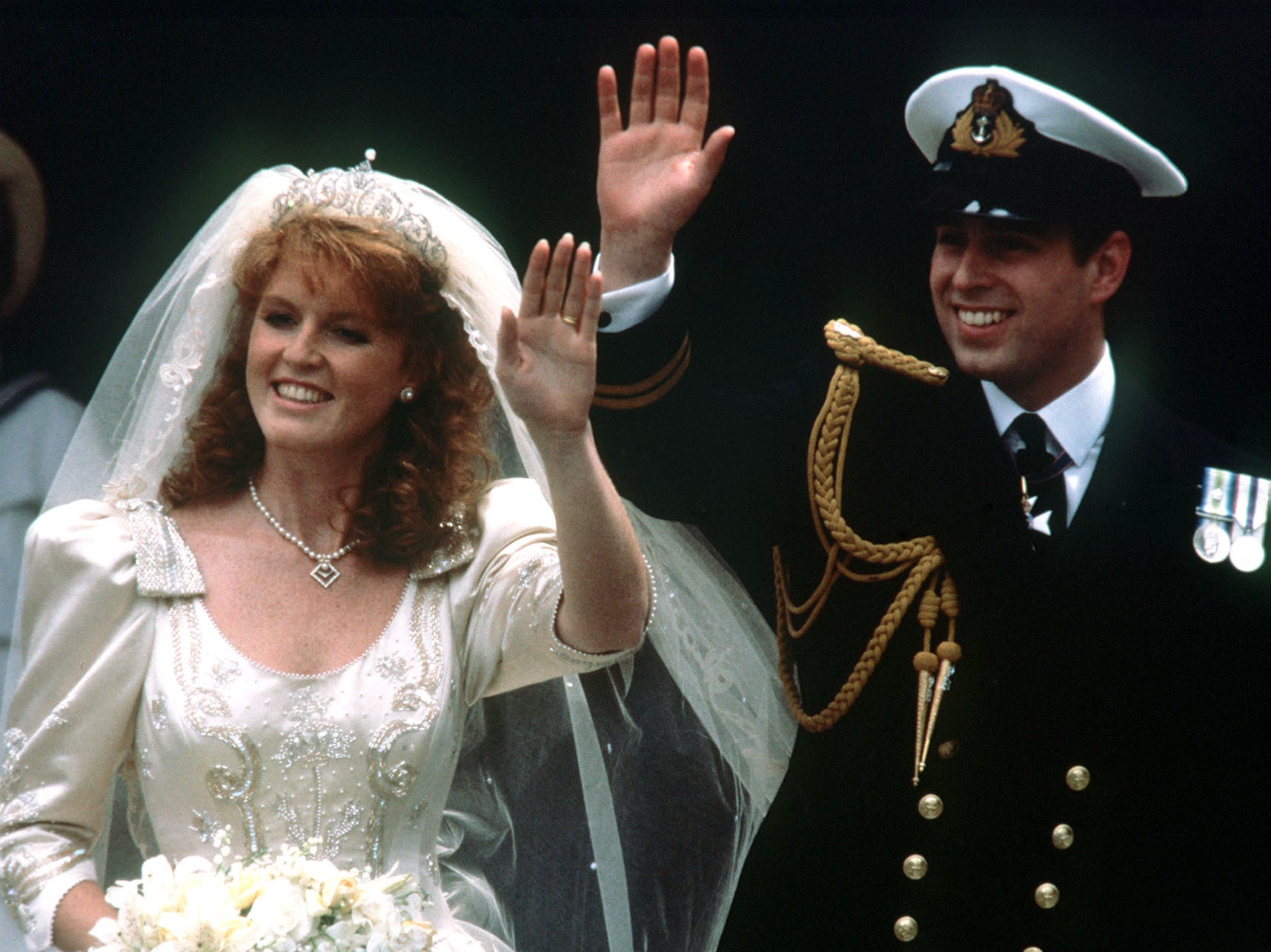 Andrew and his bride Sarah Ferguson waving to crowds as they leave Westminster Abbey in 1986