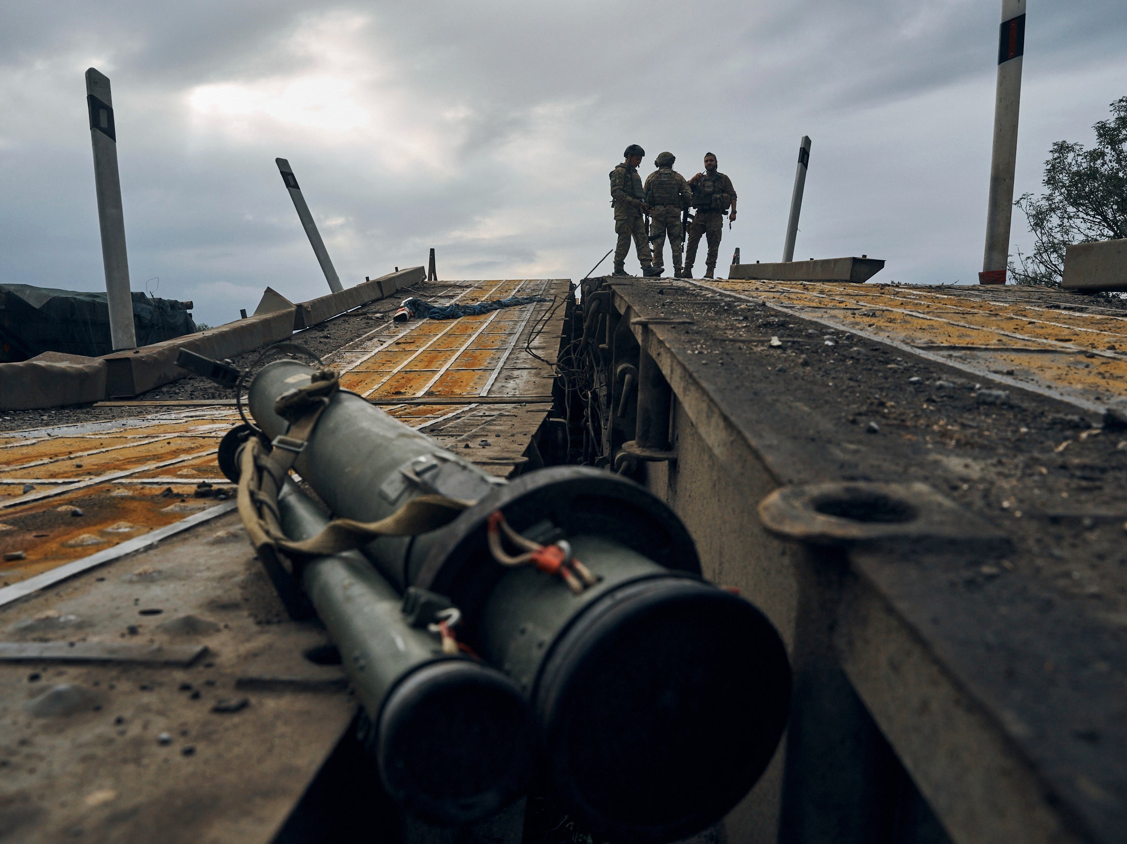 Ukrainian soldiers survey a destroyed bridge in Izium, Kharkiv region, on Tuesday