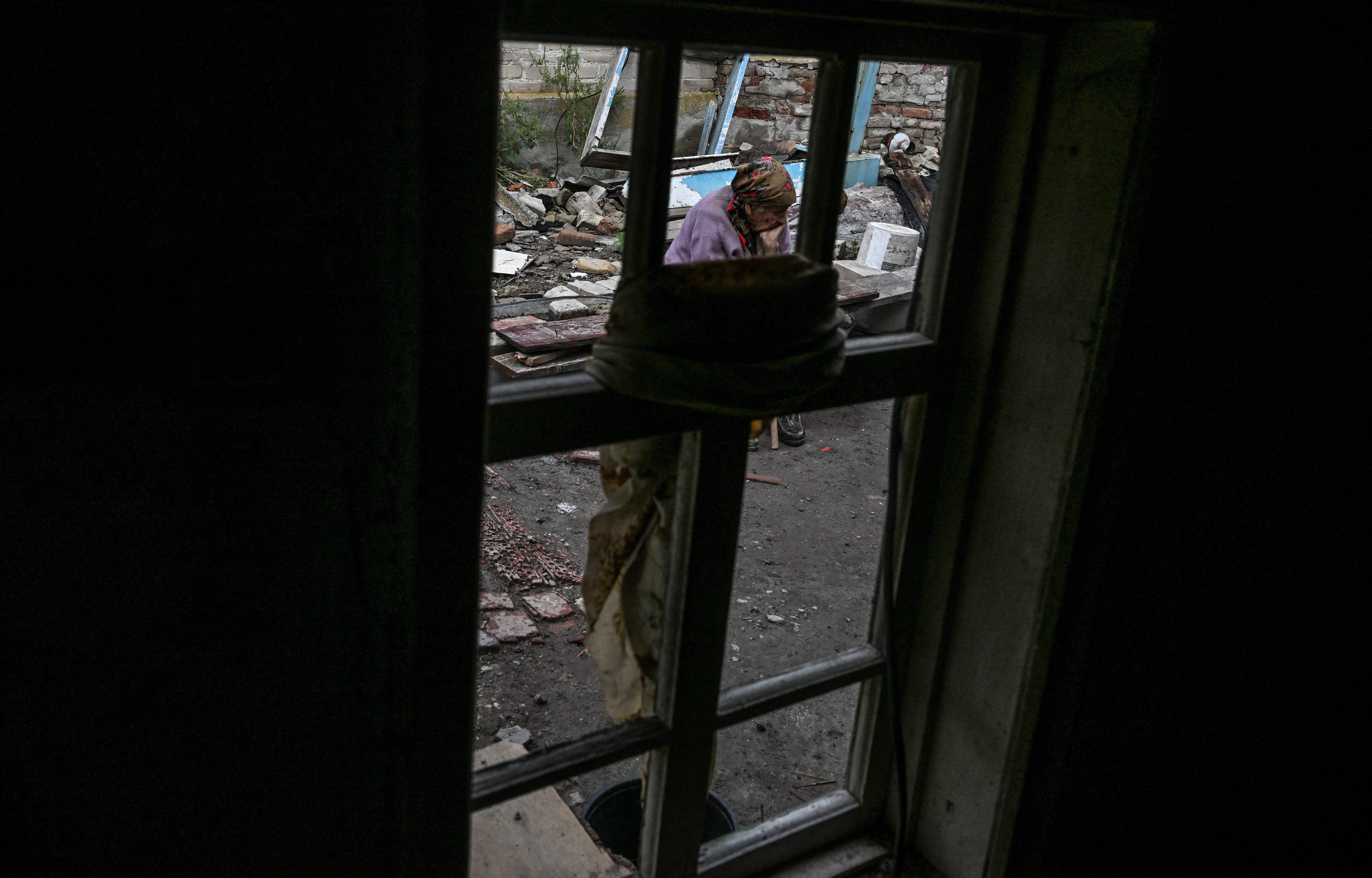 Nina Gonchar, sits in front of a destroyed house in Bohorodychne village in Kramatorsk, Donetsk region, on 13 September 2022, amid the Russian invasion of Ukraine