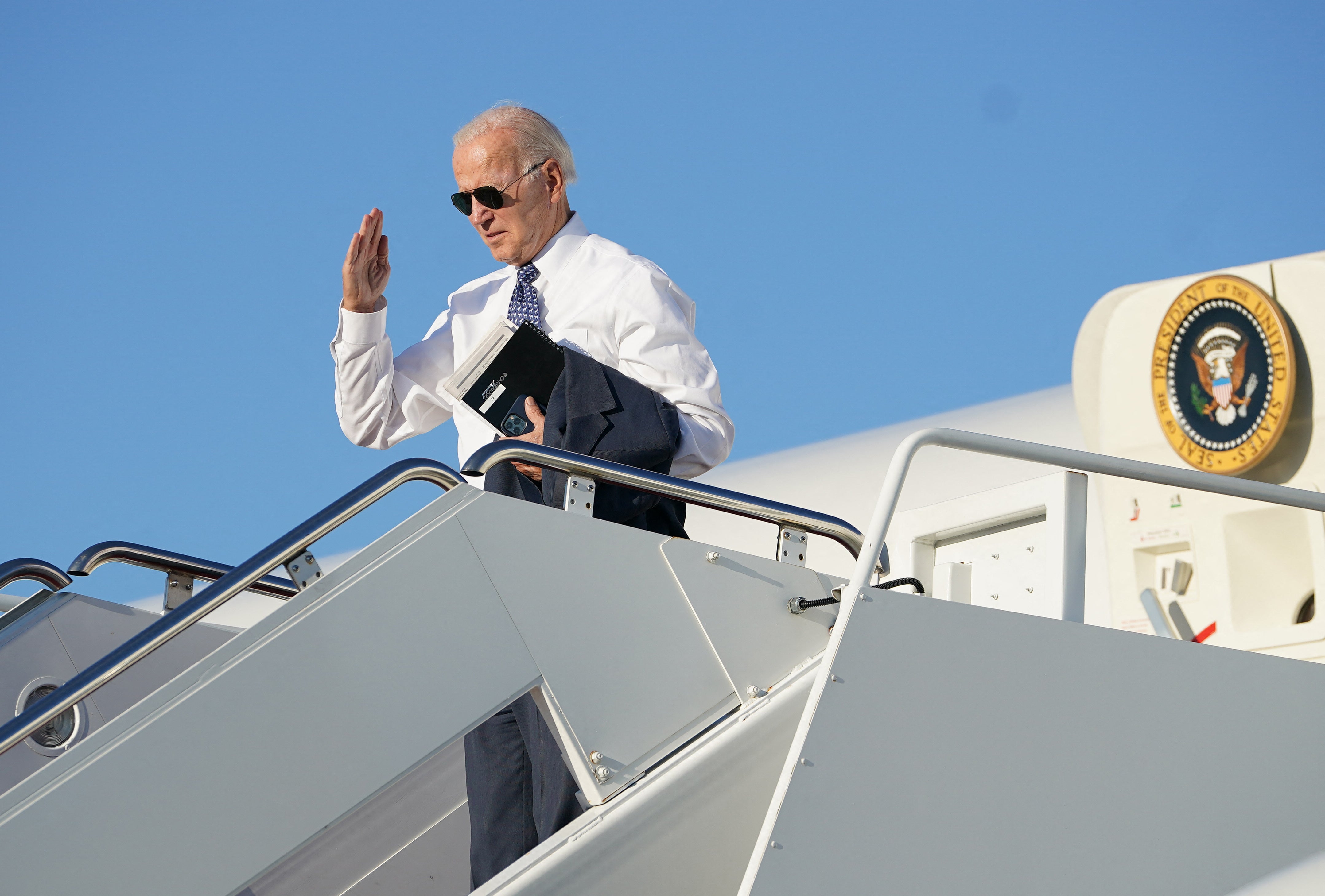 US President Joe Biden salutes as he boards Air Force One at Joint Base Andrews in Maryland, on 13 September 2022