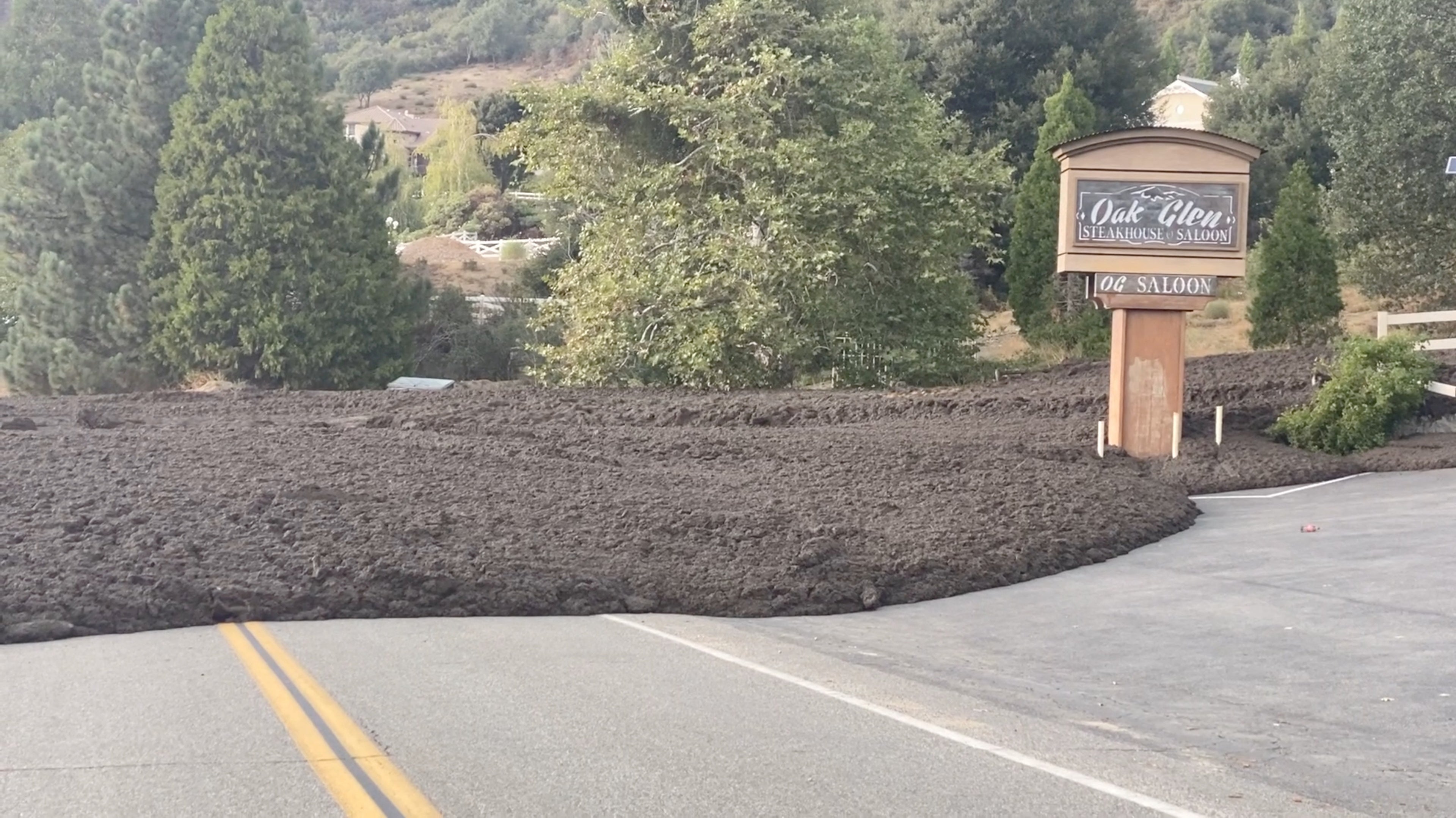 Waves of mud pour down around a restaurant in Oak Glen, California on Monday