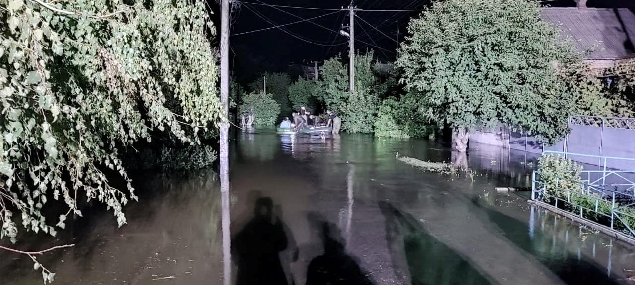 Rescuers help people to be evacuated from a flooded area after a Russian missile hit a hydraulic structure