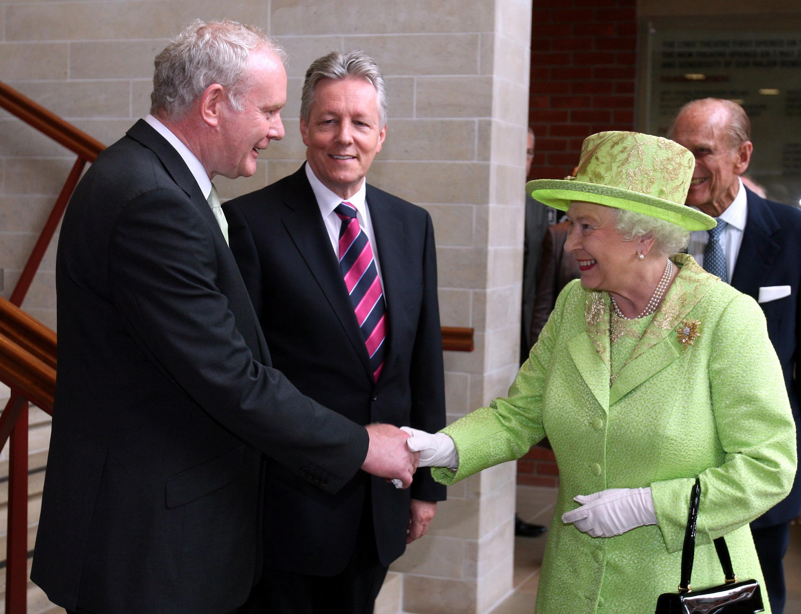 The Queen shakes hands with Northern Ireland deputy First Minister Martin McGuinness watched by First Minister Peter Robinson at the Lyric Theatre in Belfast (Paul Faith/PA)