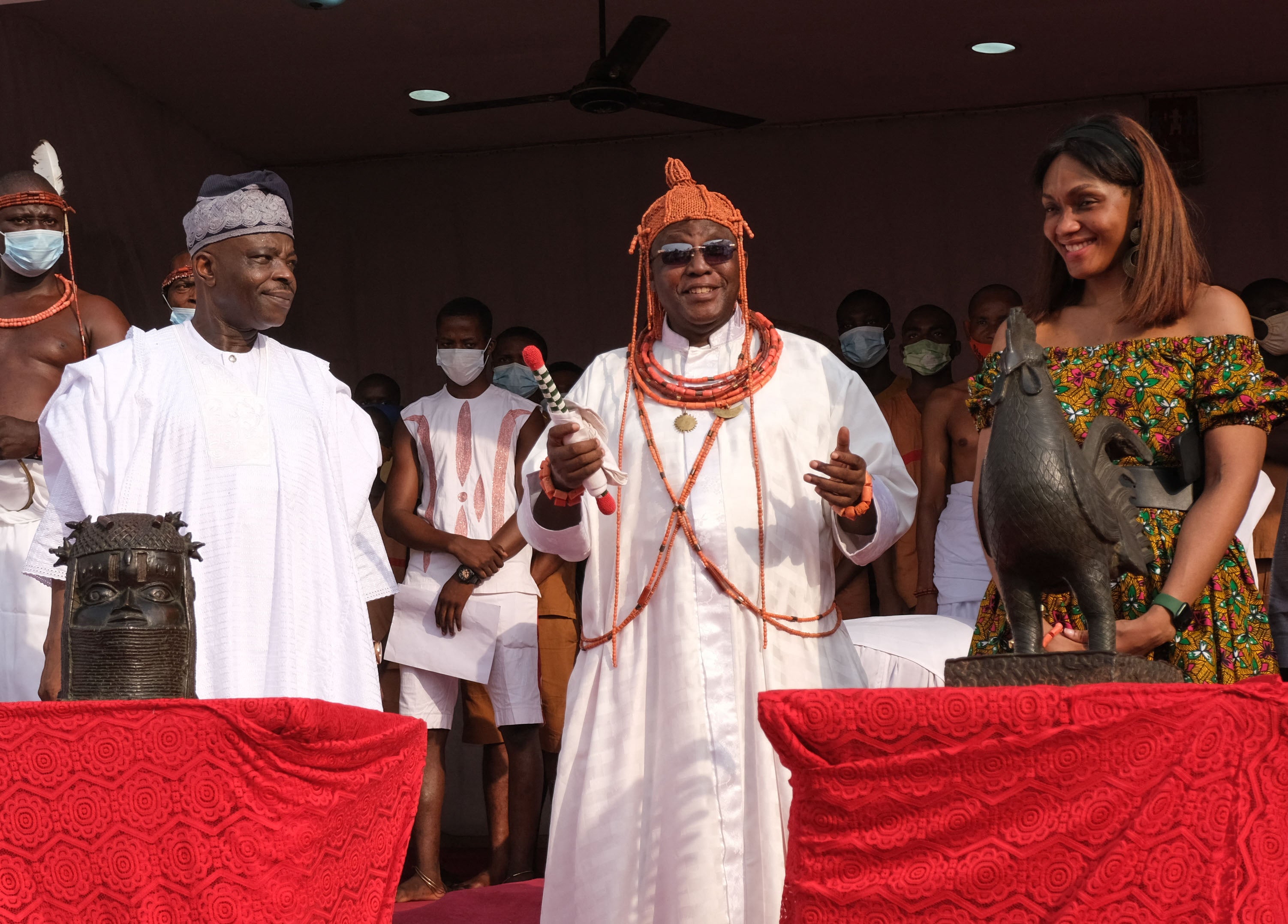 Ewuare II, known as the Oba of Benin (centre), reacts after receiving the repatriated artefacts