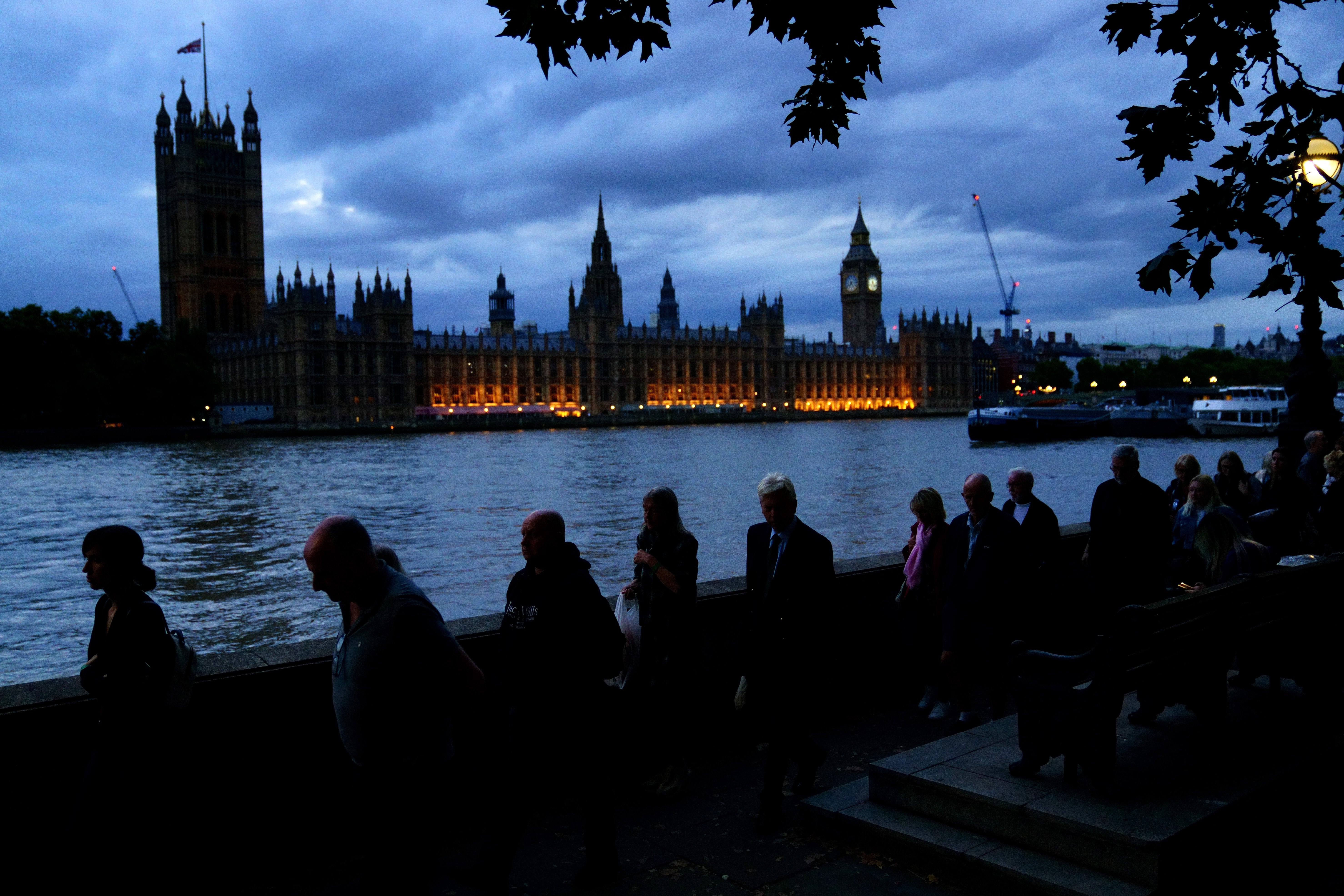 Members of the public stand in the queue on the South Bank in London opposite the Palace of Westminster, as they wait to view Queen Elizabeth II lying in state ahead of her funeral on Monday (PA)