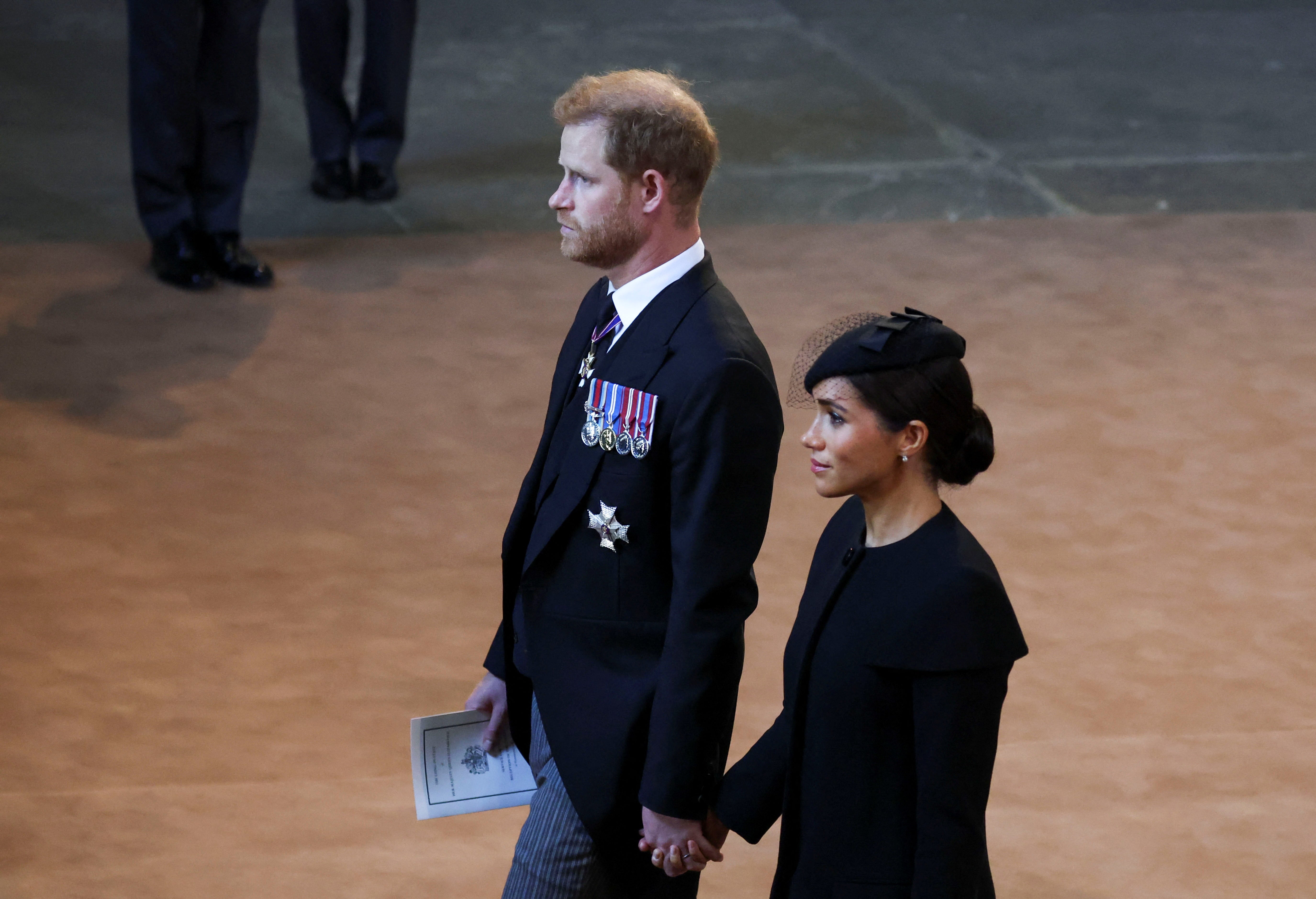 Harry and Meghan holding hands at Westminster Hall