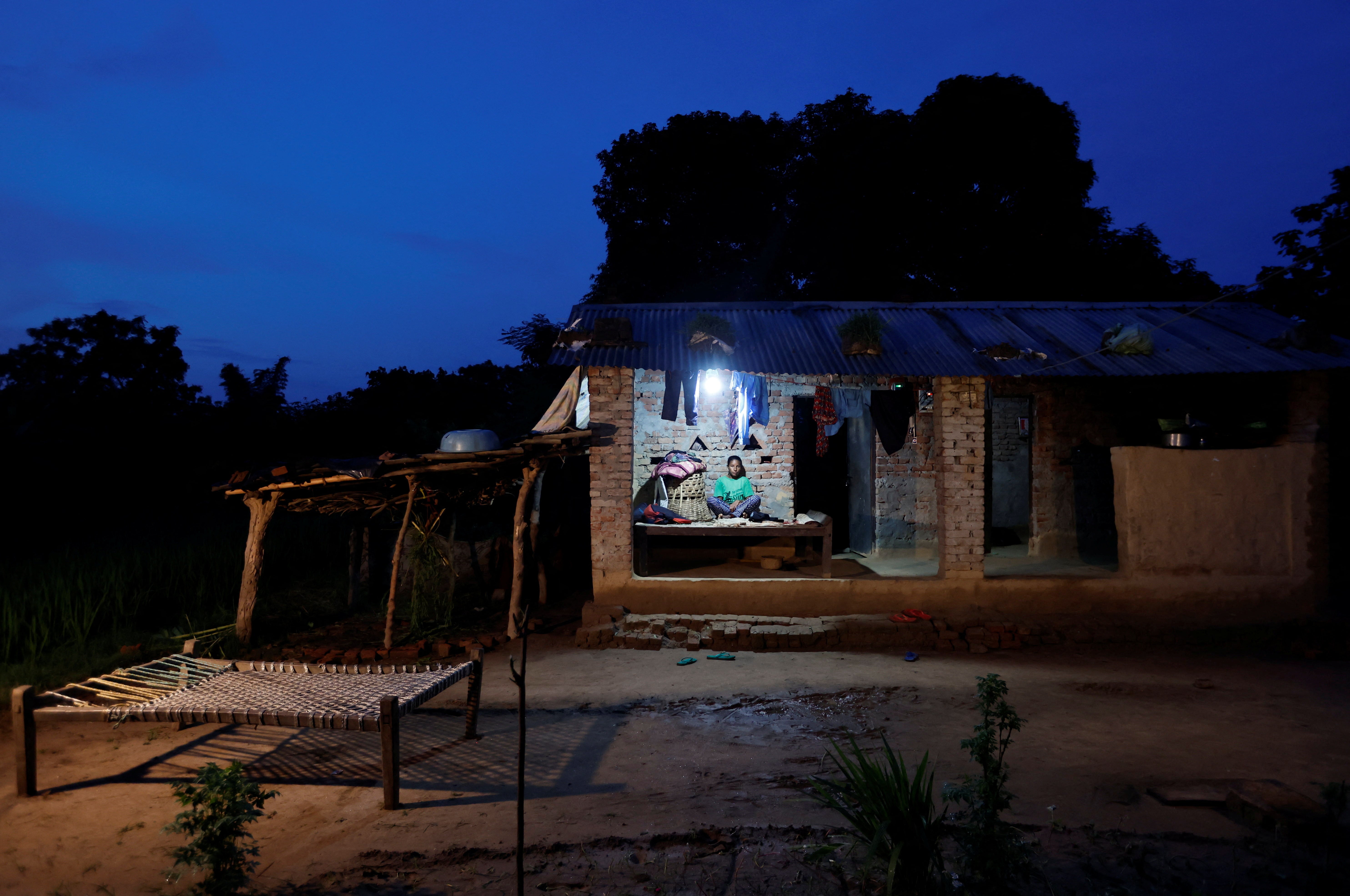 Parwati sits on the porch of her two room, tin-roofed house in Punarbas late one evening