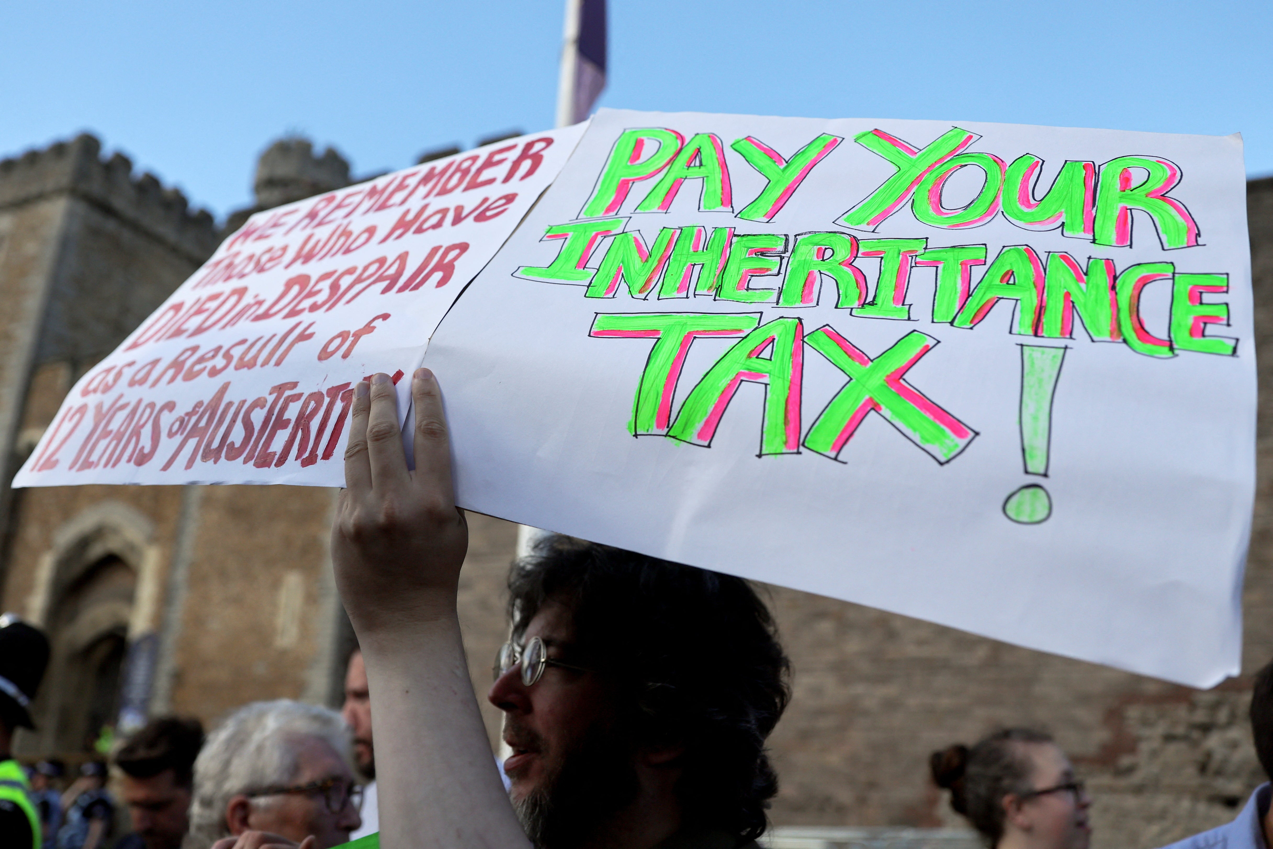 A man holds placards as he attends a protest outside Cardiff Castle