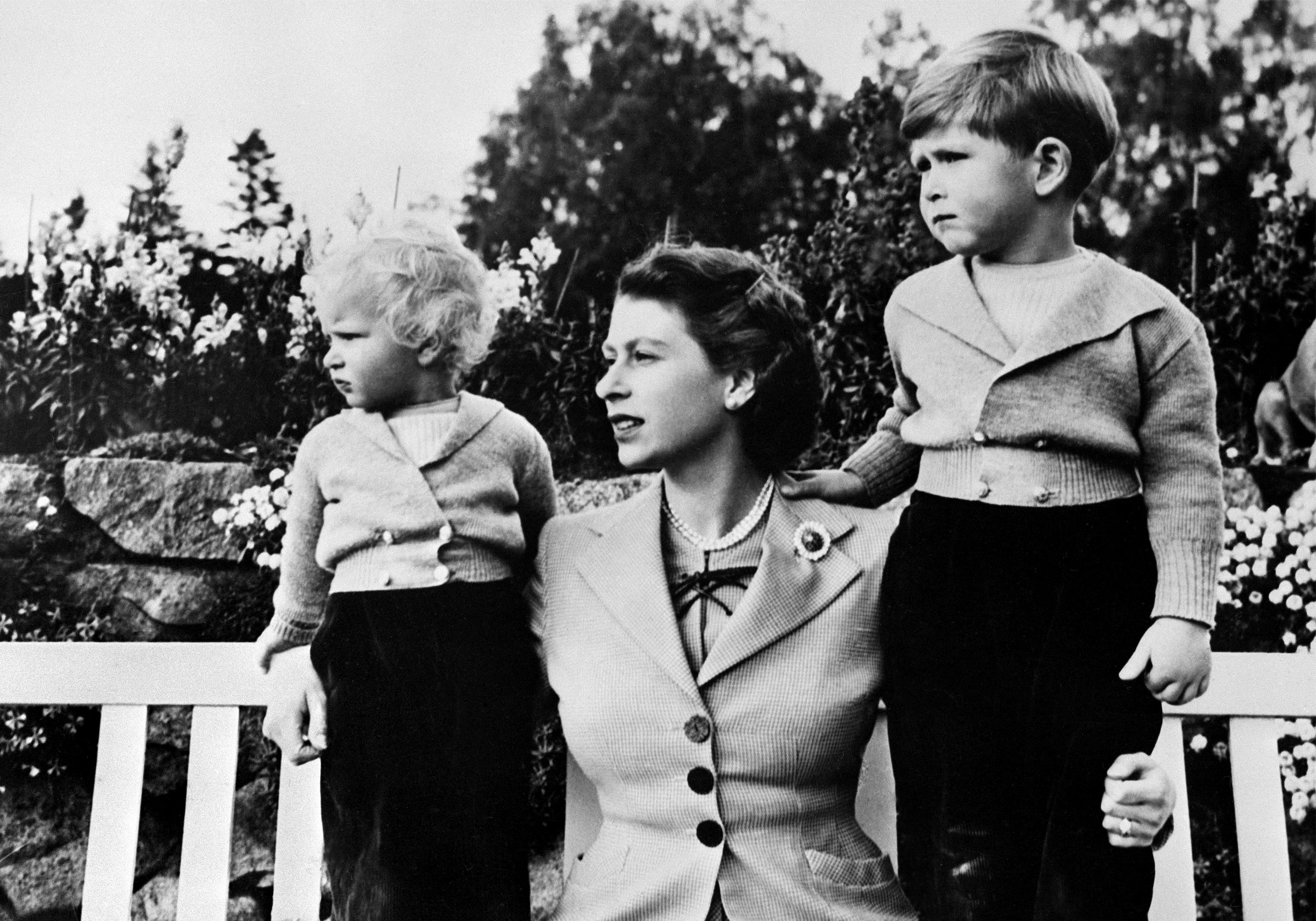 Photo of the Queen Elizabeth II with her two children Charles (R) and Anne, at Balmoral in 1954 (Photo by - / AFP) (Photo by -/-/AFP via Getty Images)