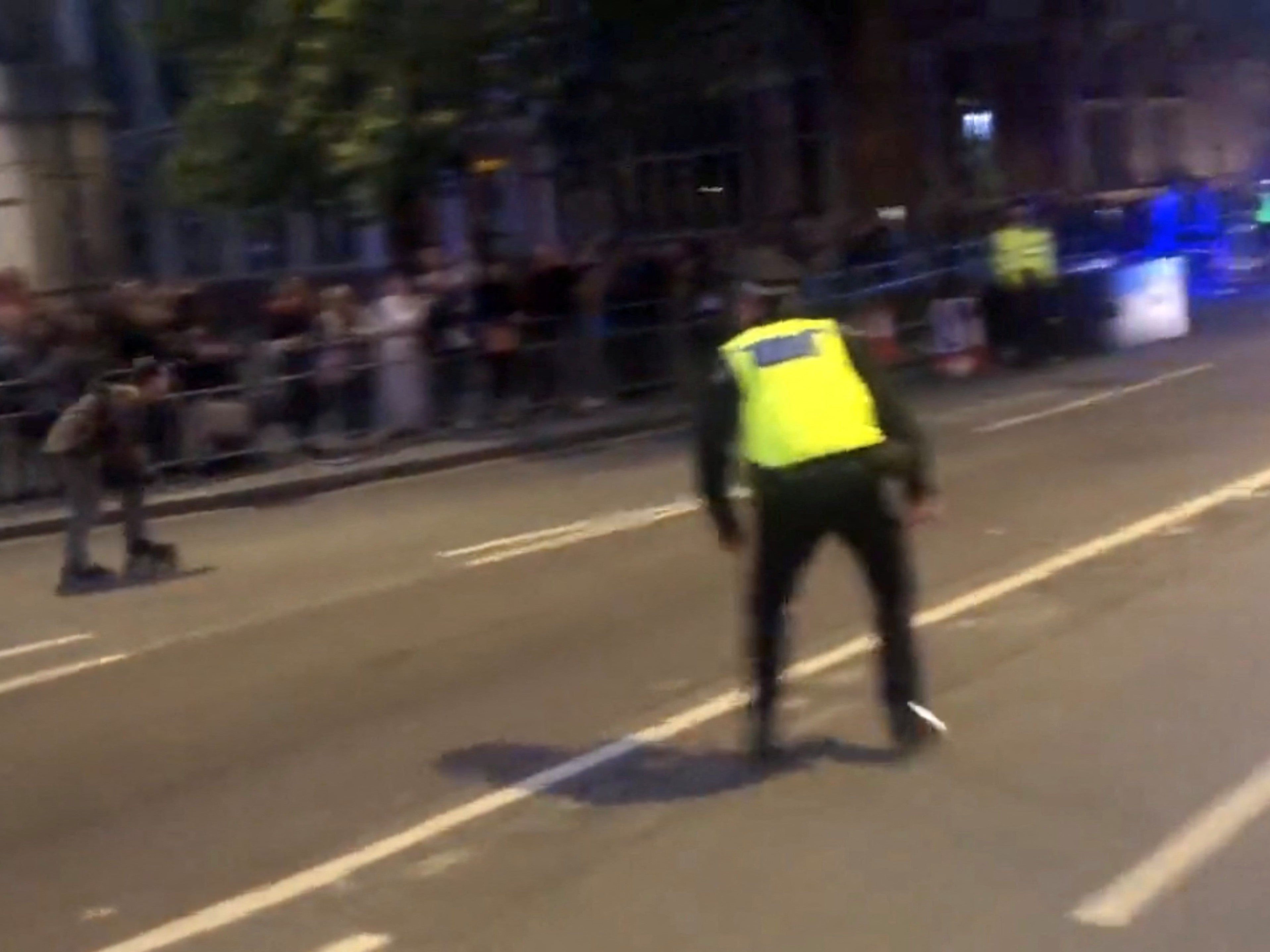 Police charge towards a rollerskater ahead of King Charles’ motorcade passing by