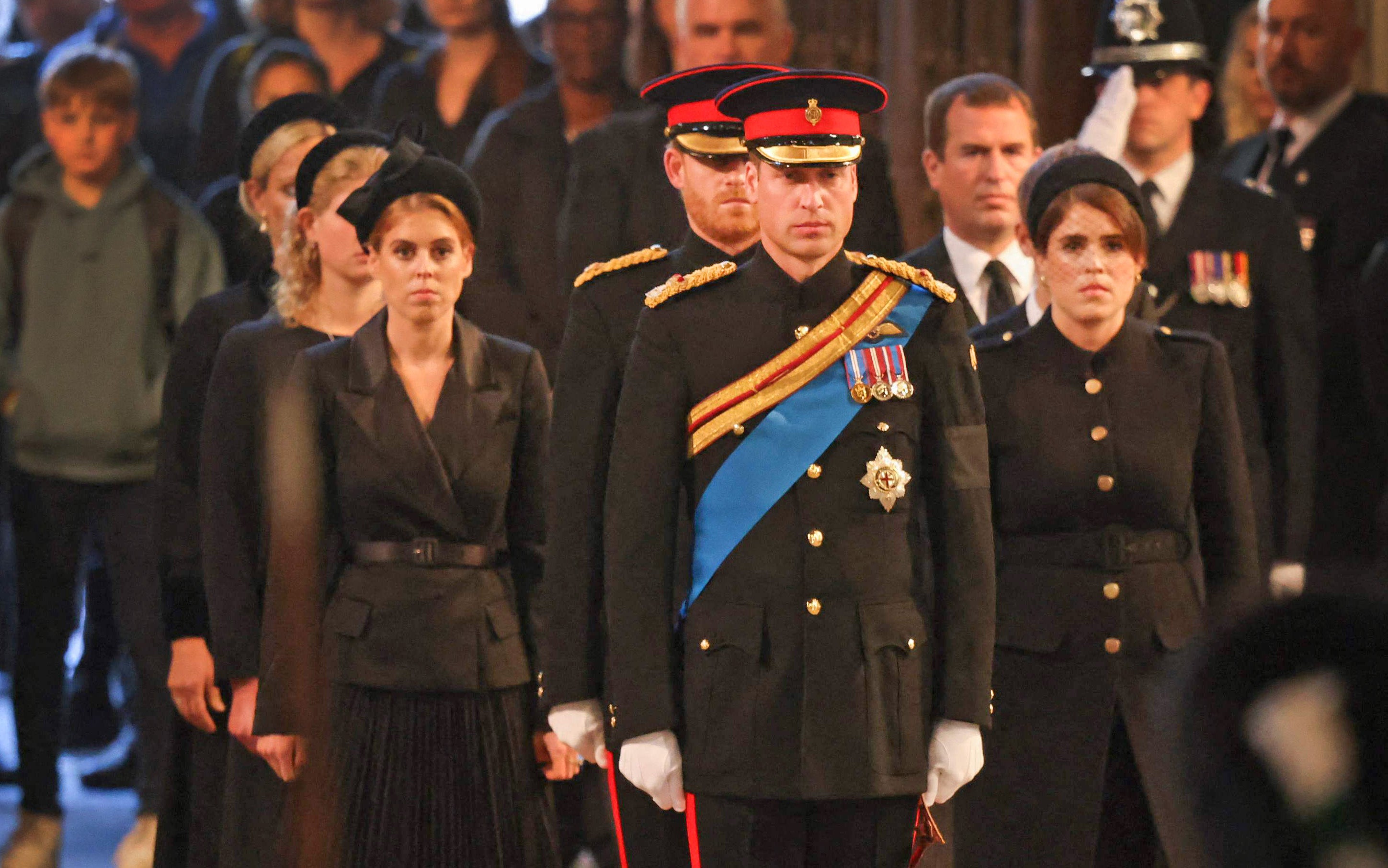 Princesses Beatrice and Eugenie walk behind Prince William as they process towards the Queen’s coffin