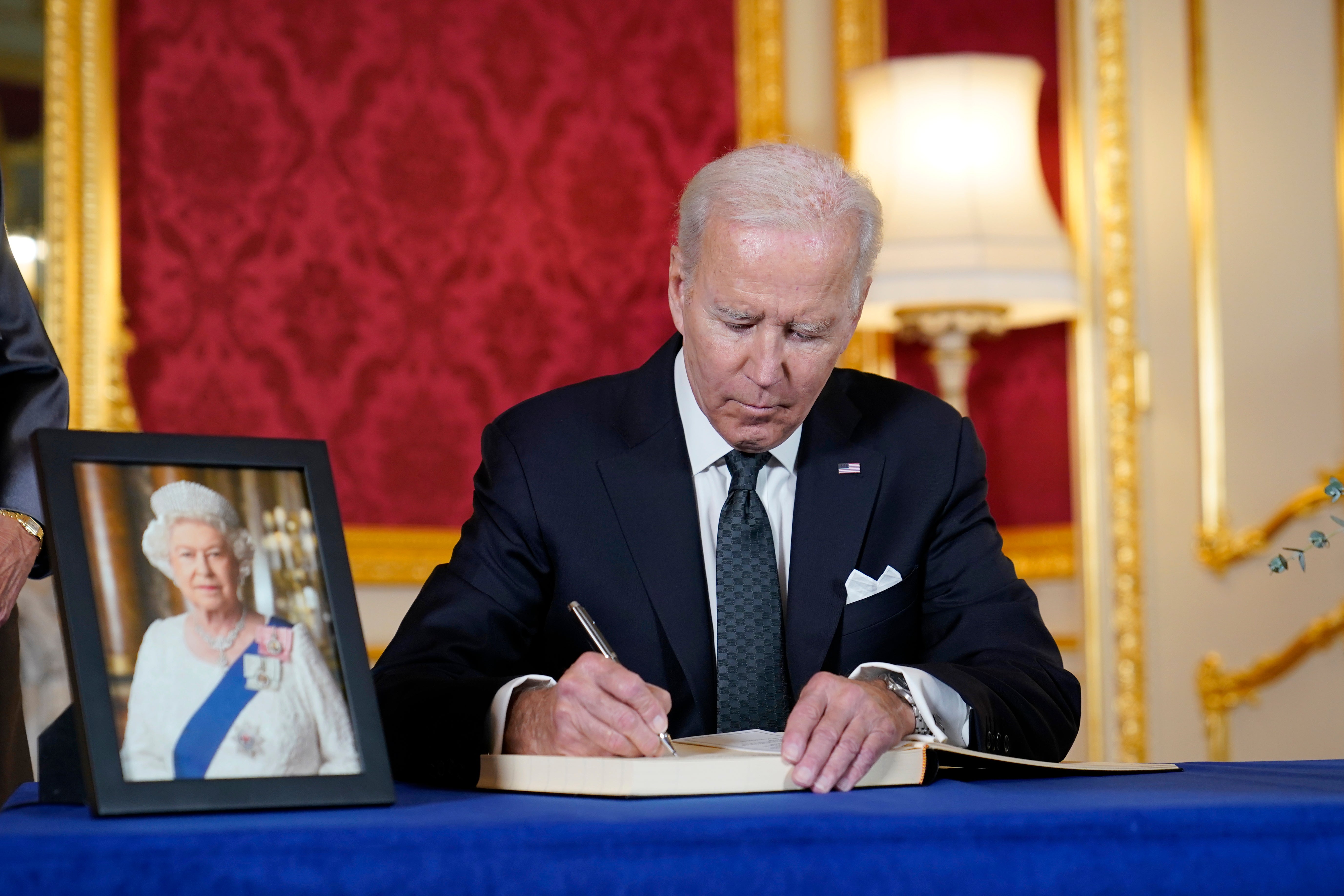 President Biden signs a book of condolence at Lancaster House in London