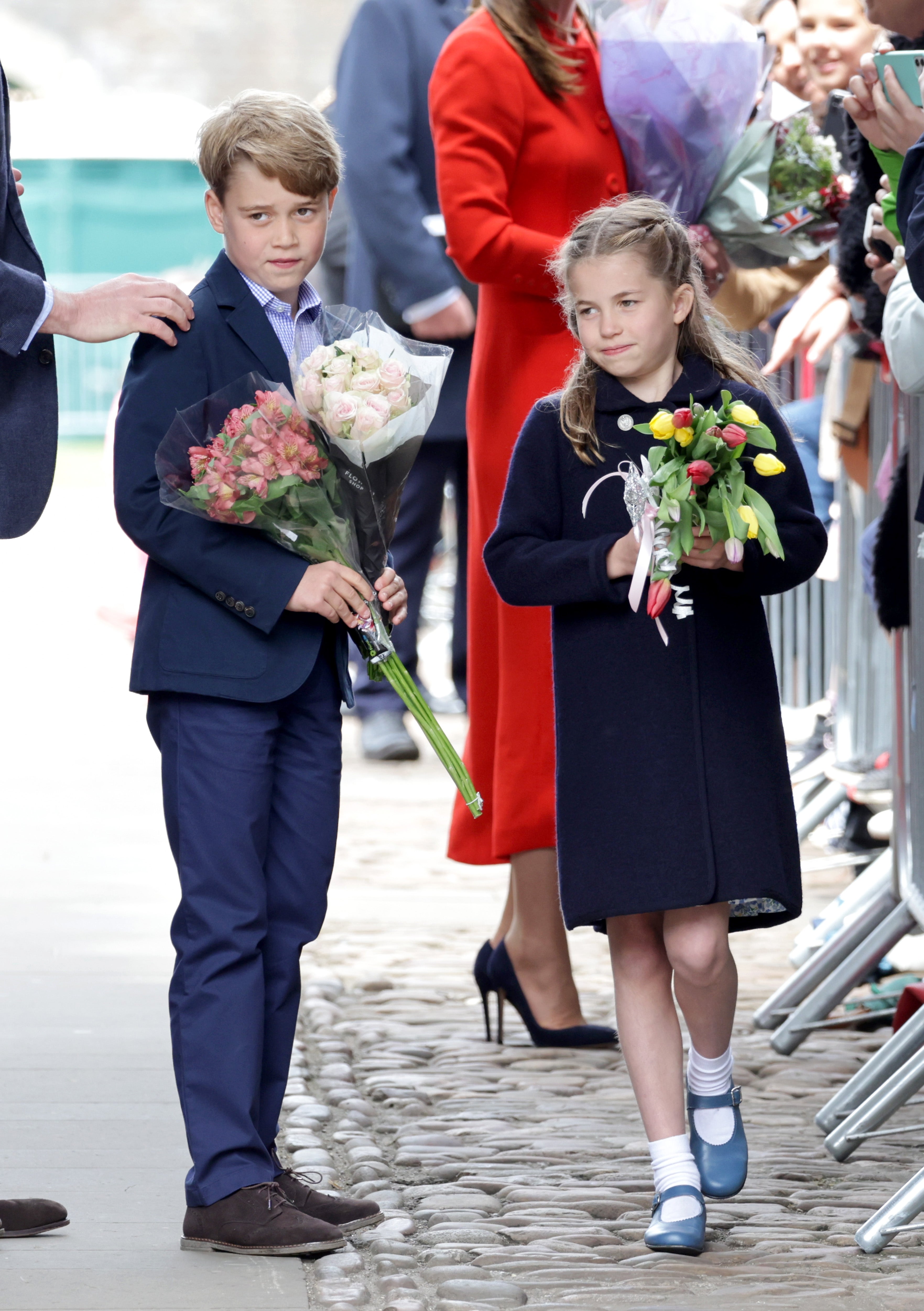 George and Charlotte of Cambridge hold gifts of flowers