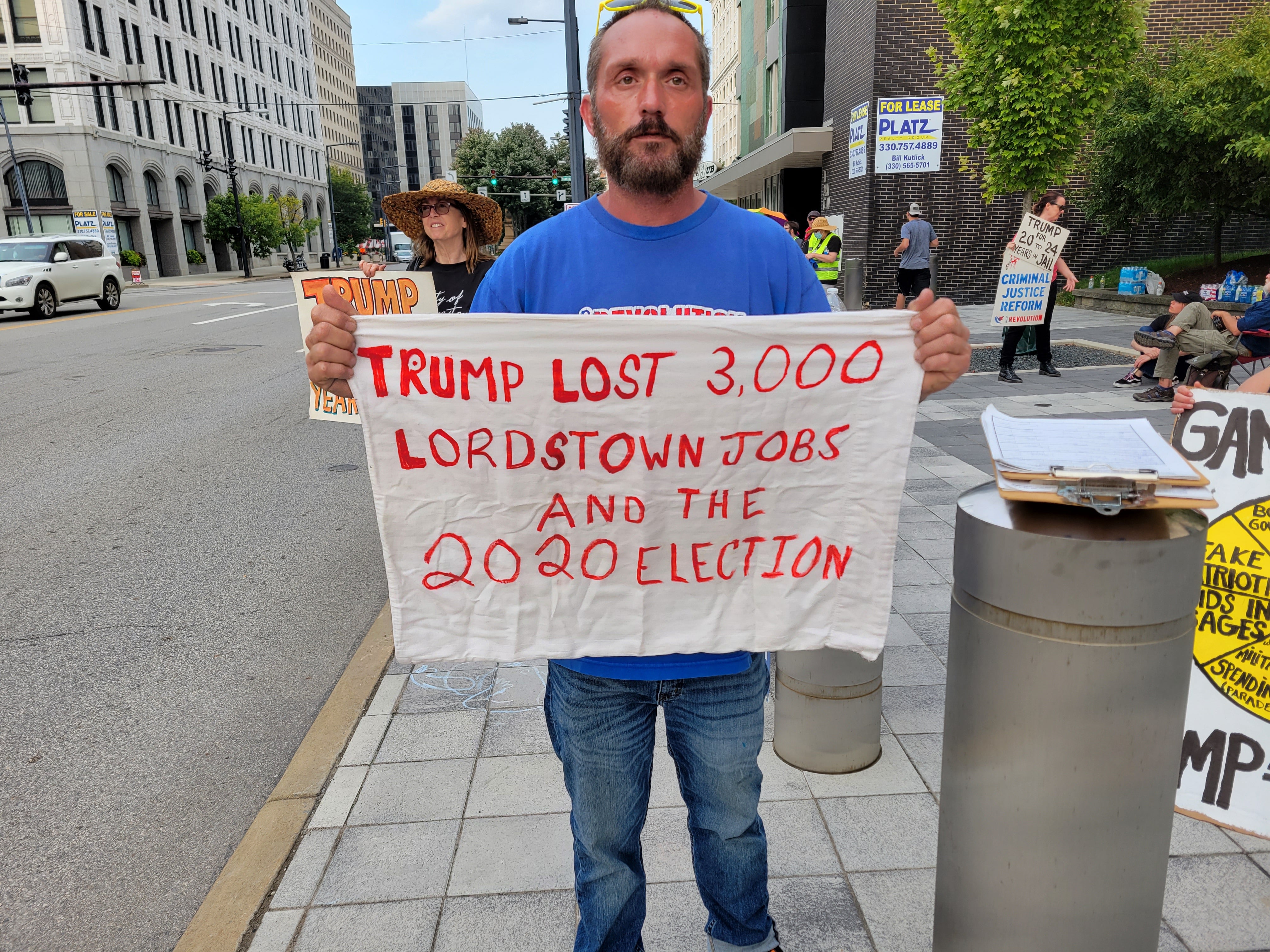 Chucky Dennison holds up his banner before attending Donald Trump’s rally in Youngstown, Ohio