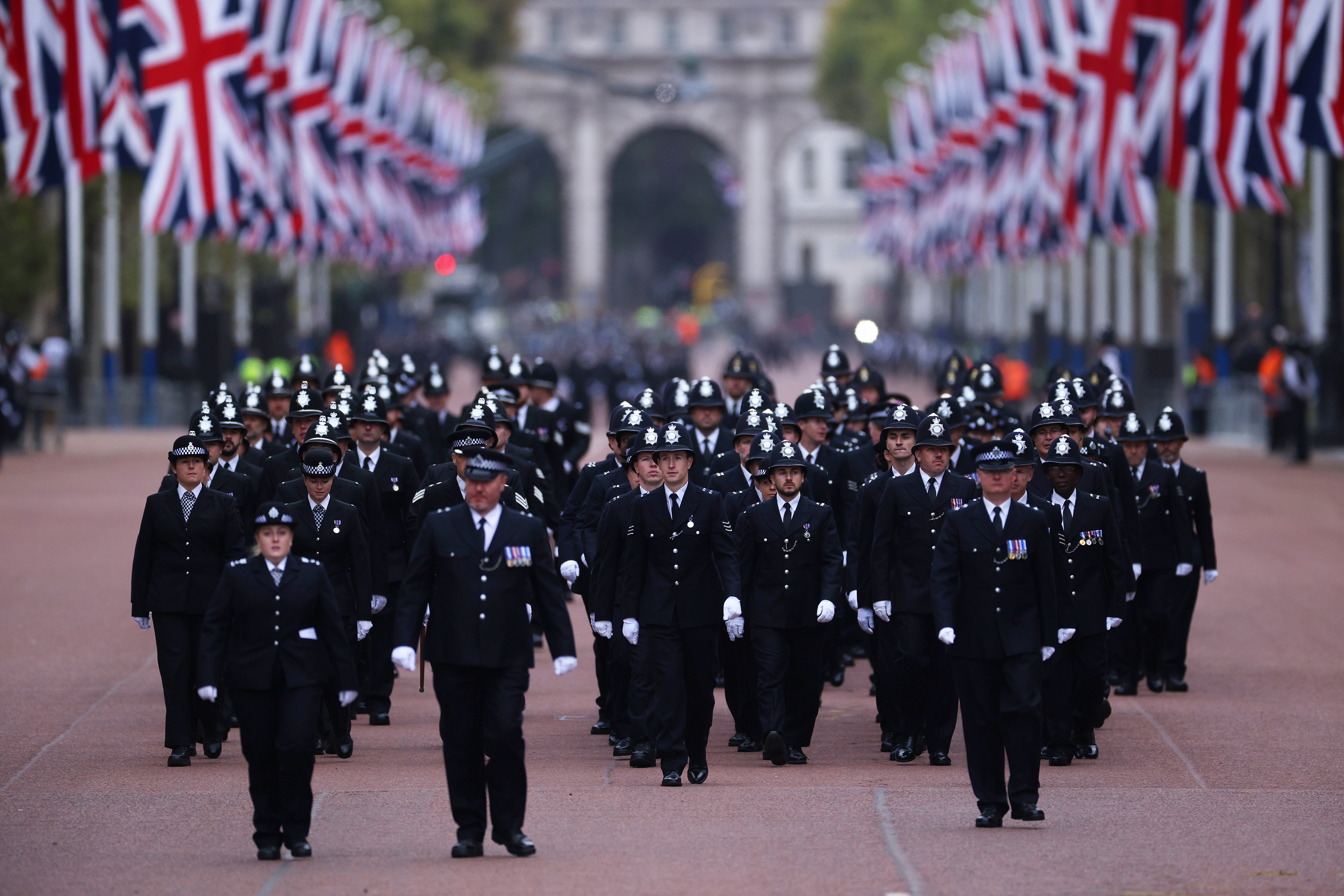 Metropolitan Police Officers are seen walking in formation down The Mall