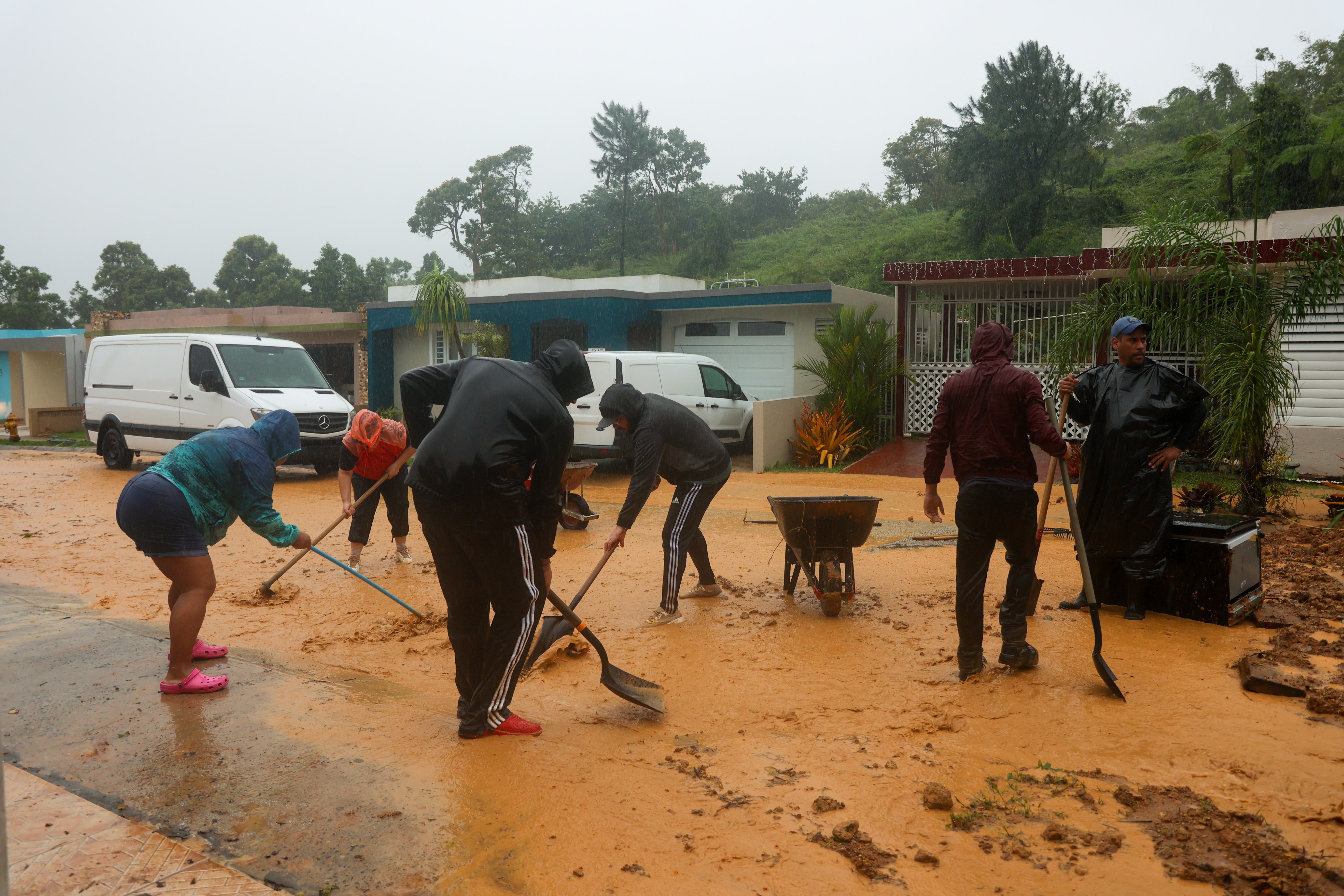 People clean debris from a road after a mudslide caused by Hurricane Fiona in Cayey, Puerto Rico, Sunday, 18 September 2022