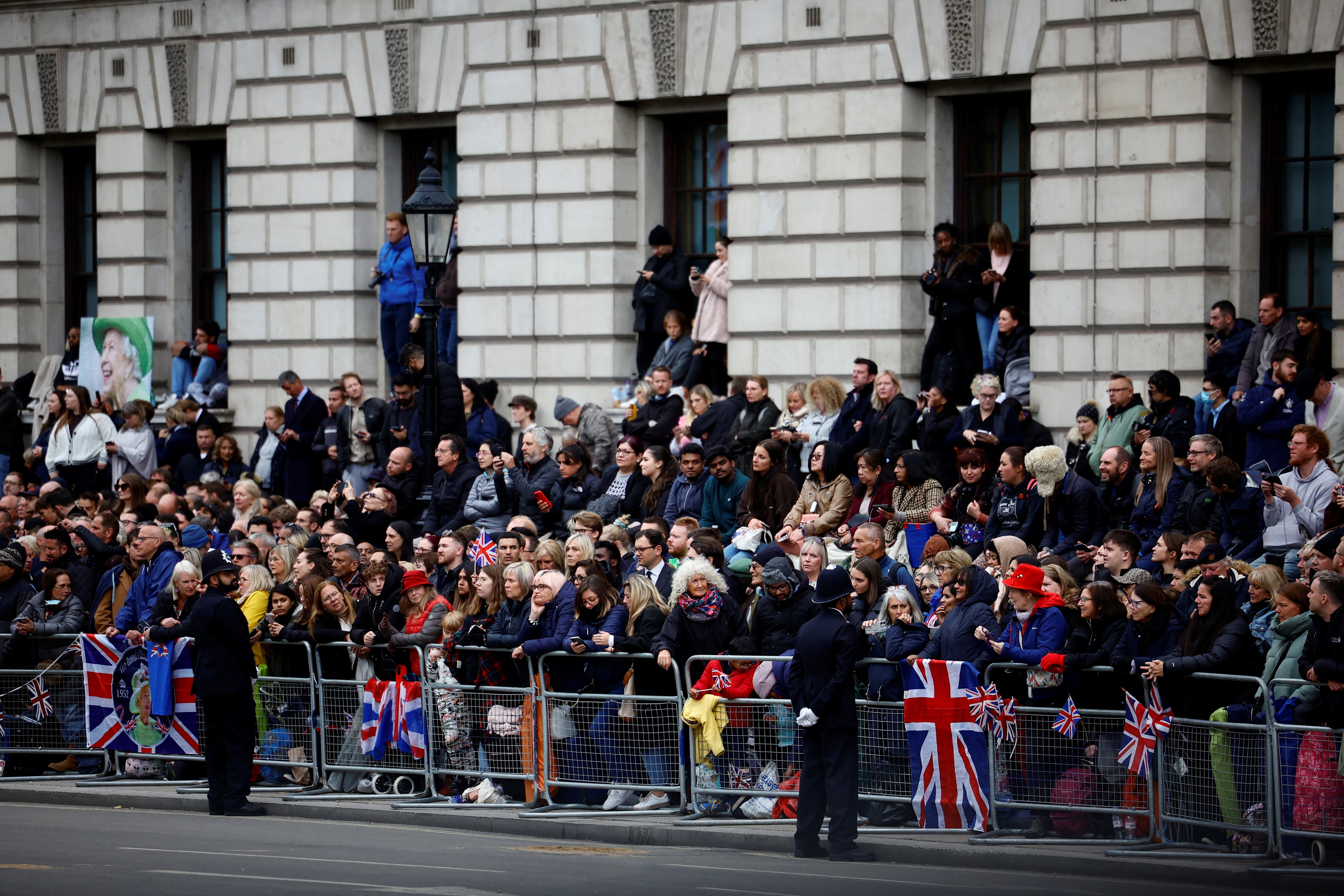 People gather to watch the funeral and burial of Britain's Queen Elizabeth, at Parliament Square in London