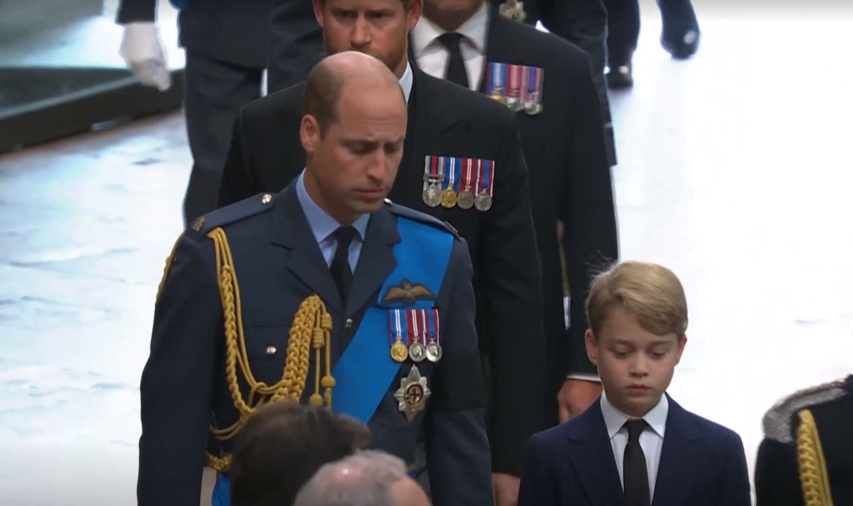 Prince George walks alongside his father, the Prince of Wales