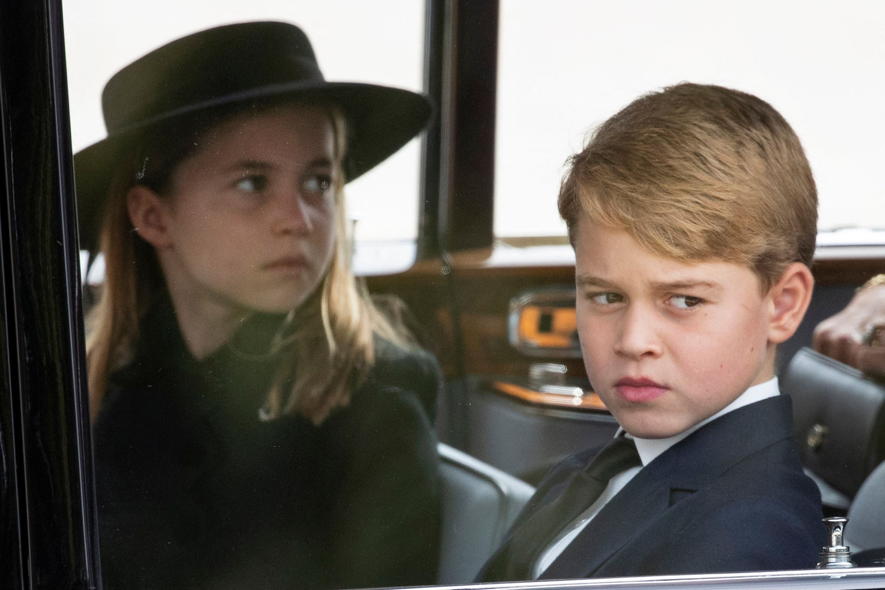 Princess Charlotte and Prince George follow the coffin by car after the service at Westminster Hall