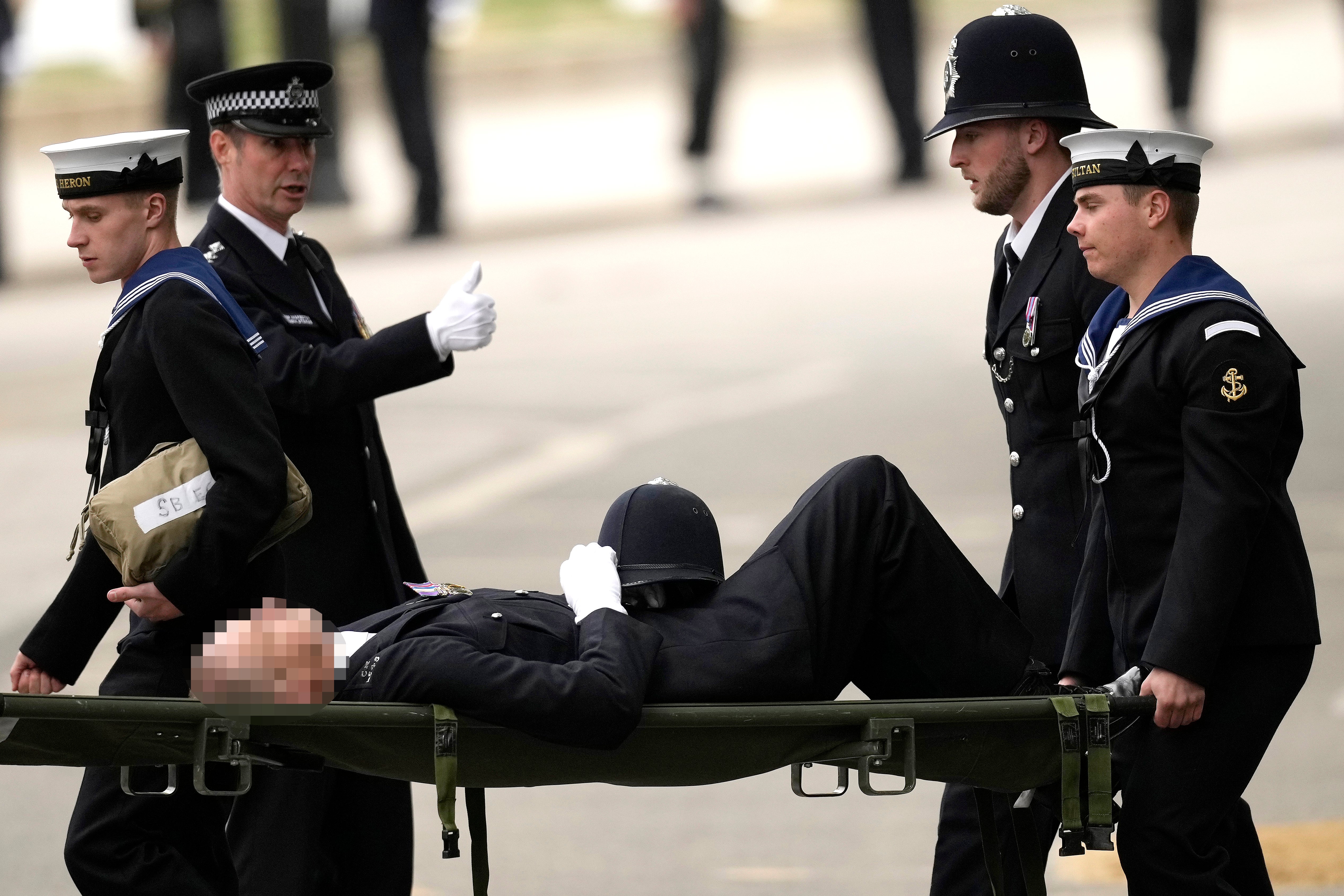 A member of the Metropolitan Police carried away on a stretcher by two members of the Royal Navy ahead of the State Funeral of Queen Elizabeth II