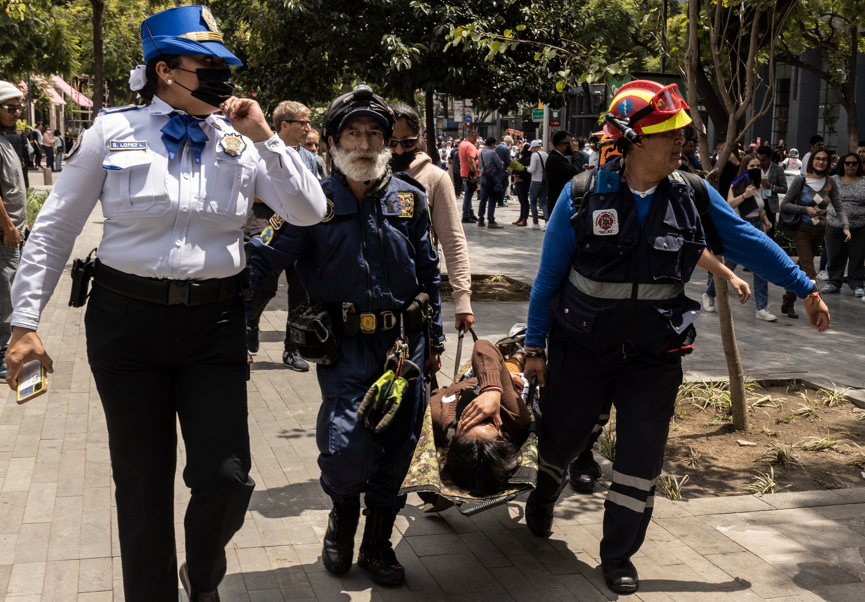 Rescuers carry a person on a stretcher after a 7.7 magnitude quake that struck the west coast in Michoacan State, was felt in Mexico City