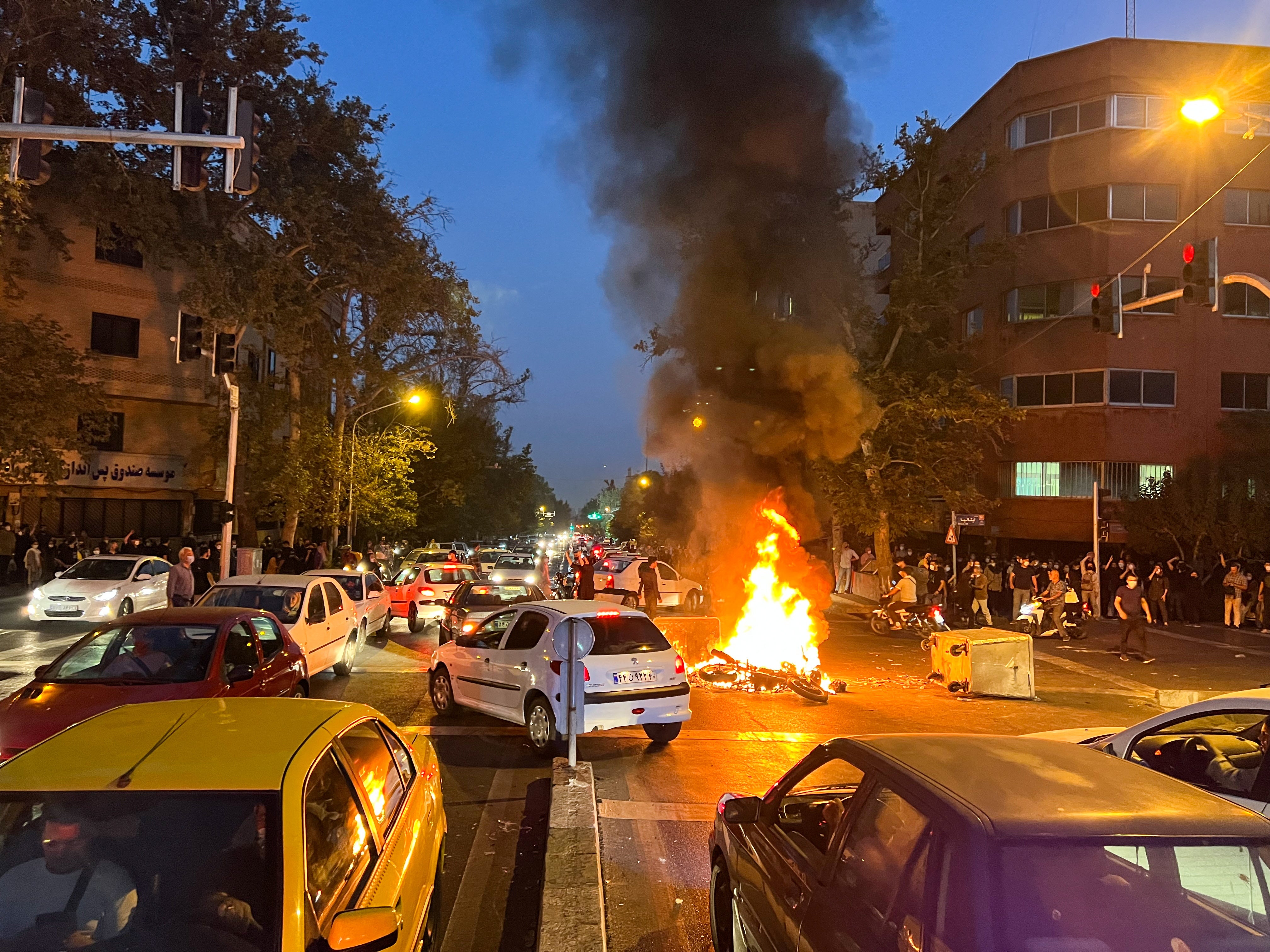 A police motorcycle burns during a protest over the death of Mahsa Amin in Tehran