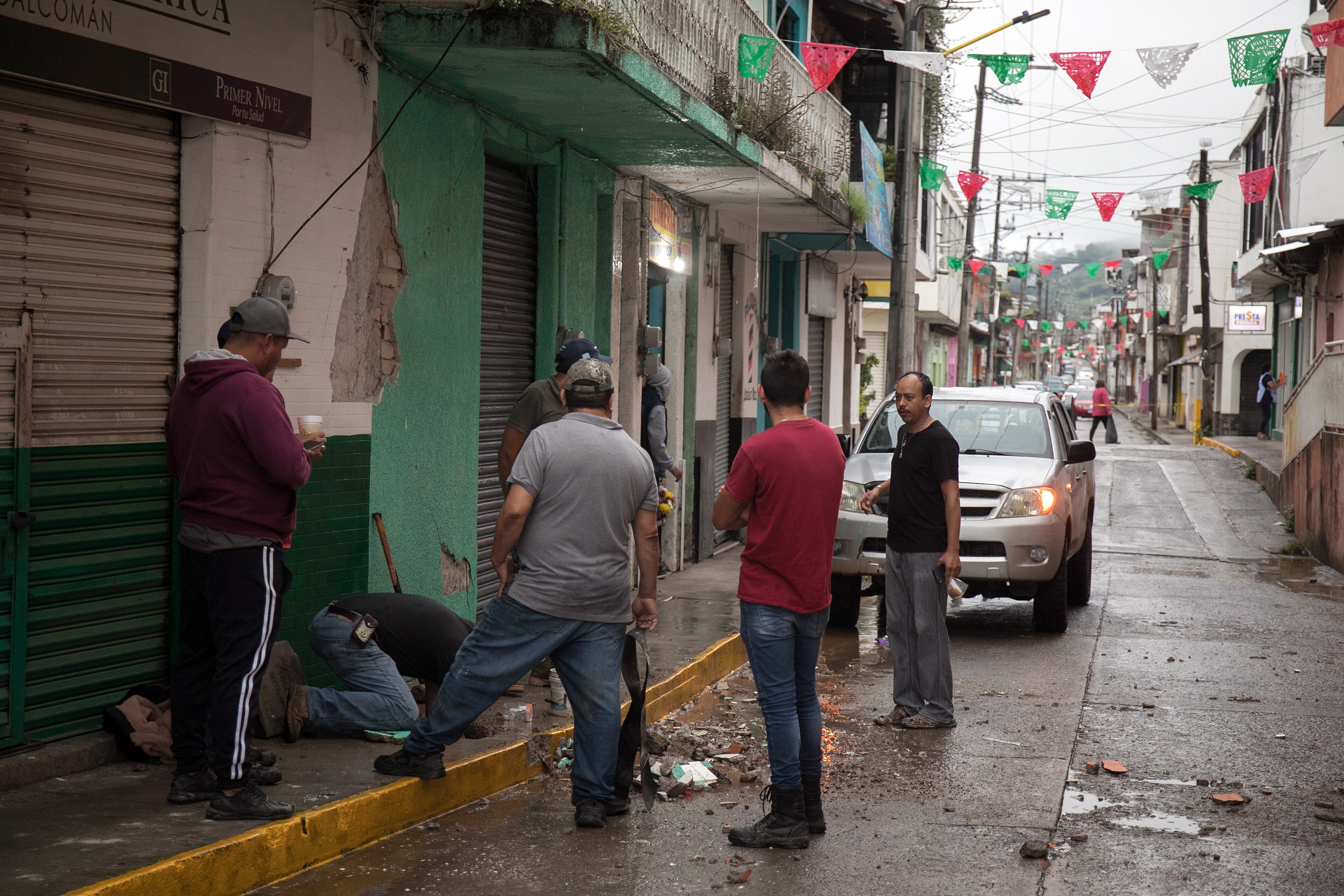 People clean debris after yesterday's 7.7-earthquake in Coalcoman, Michoacan, Mexico, on 20 September 2022