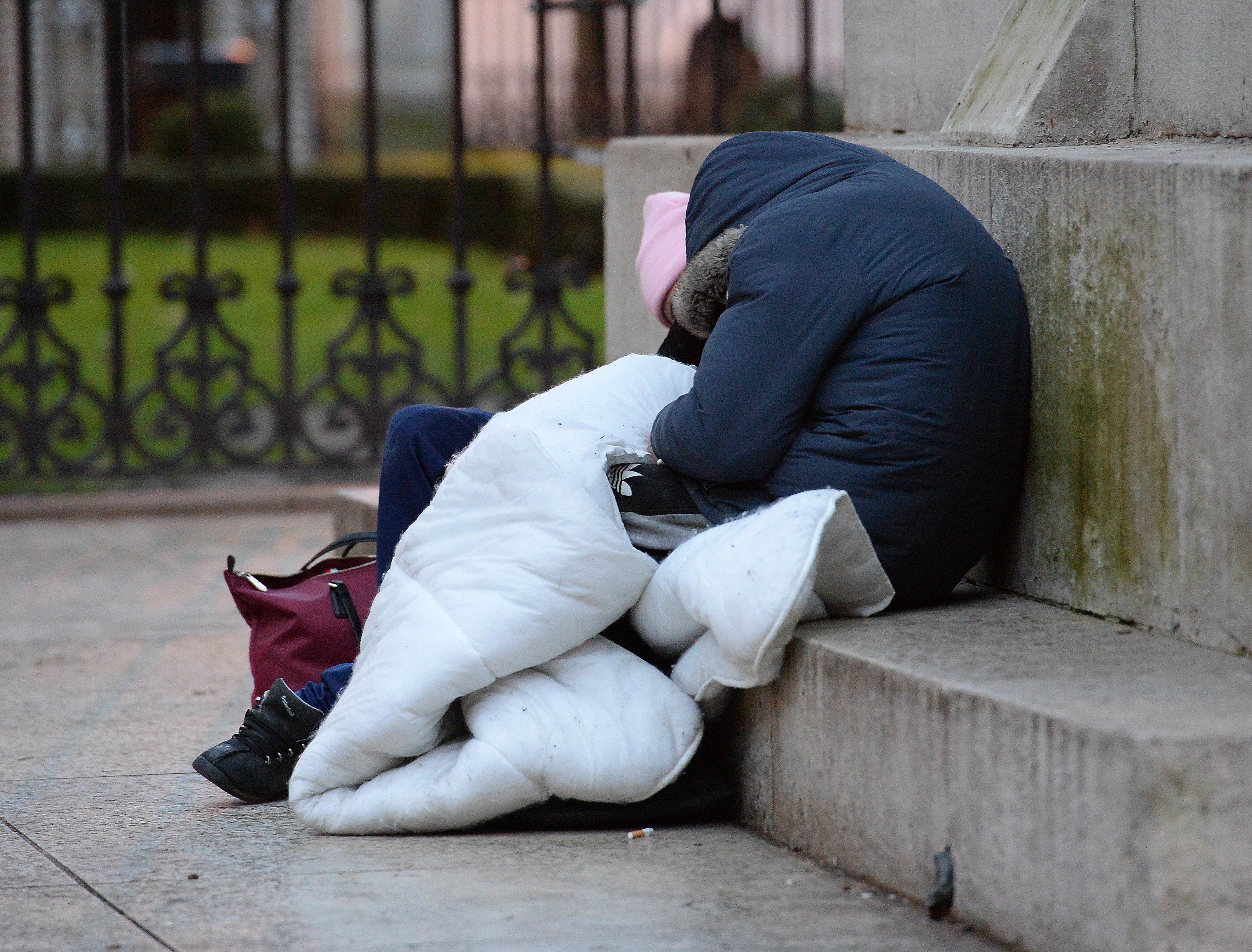 A person sleeps on the plinth of the Ferdinand Foch equestrian statue in Victoria, London