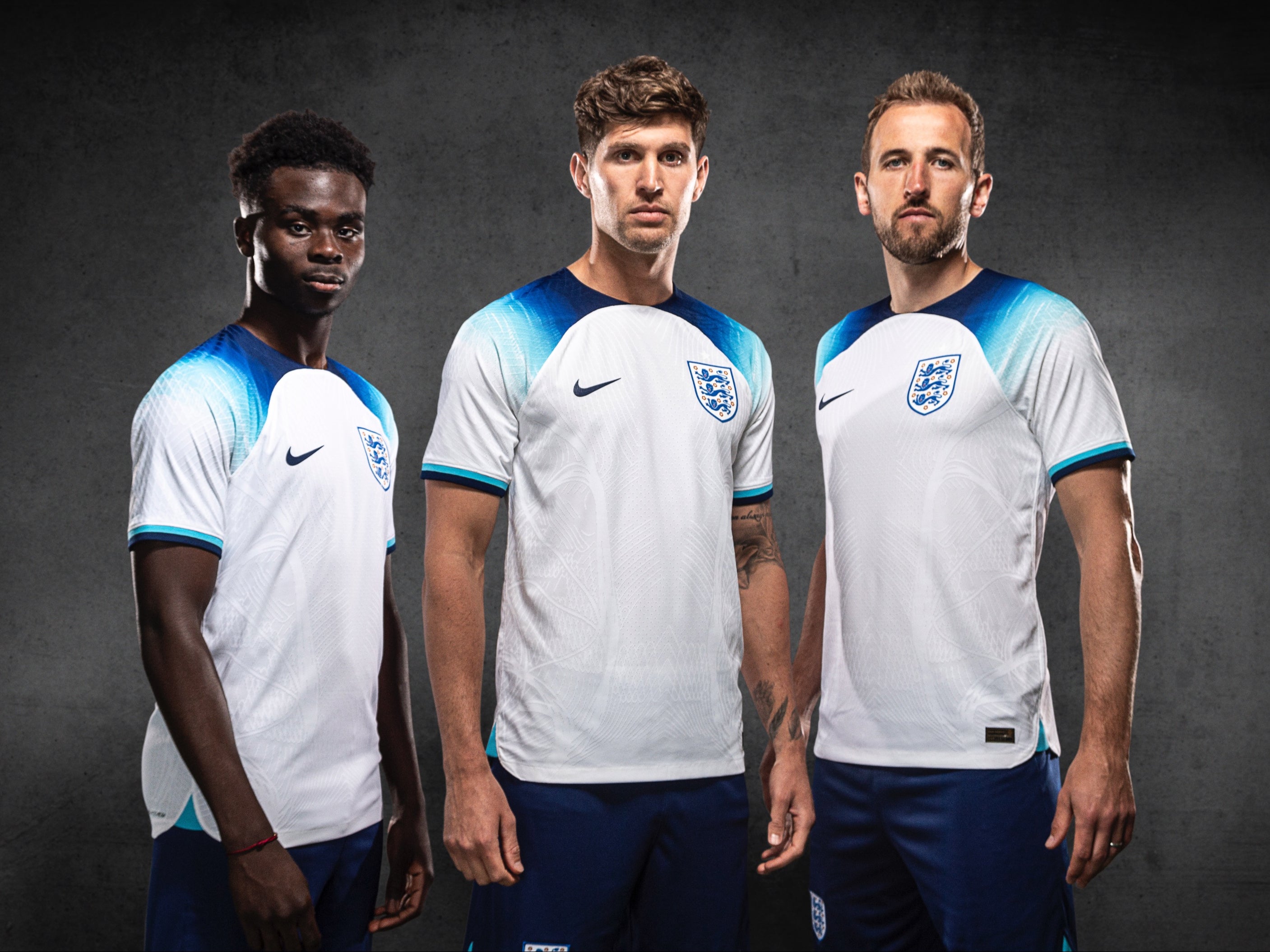 Bukayo Saka, John Stones and Harry Kane pose in England’s official home kit for the 2022 World Cup