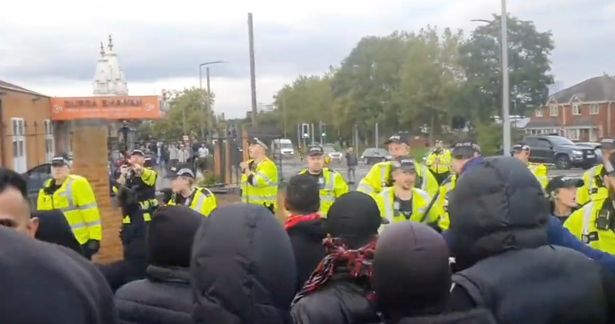 Riot police can be seen standing around the temple in Smethwick